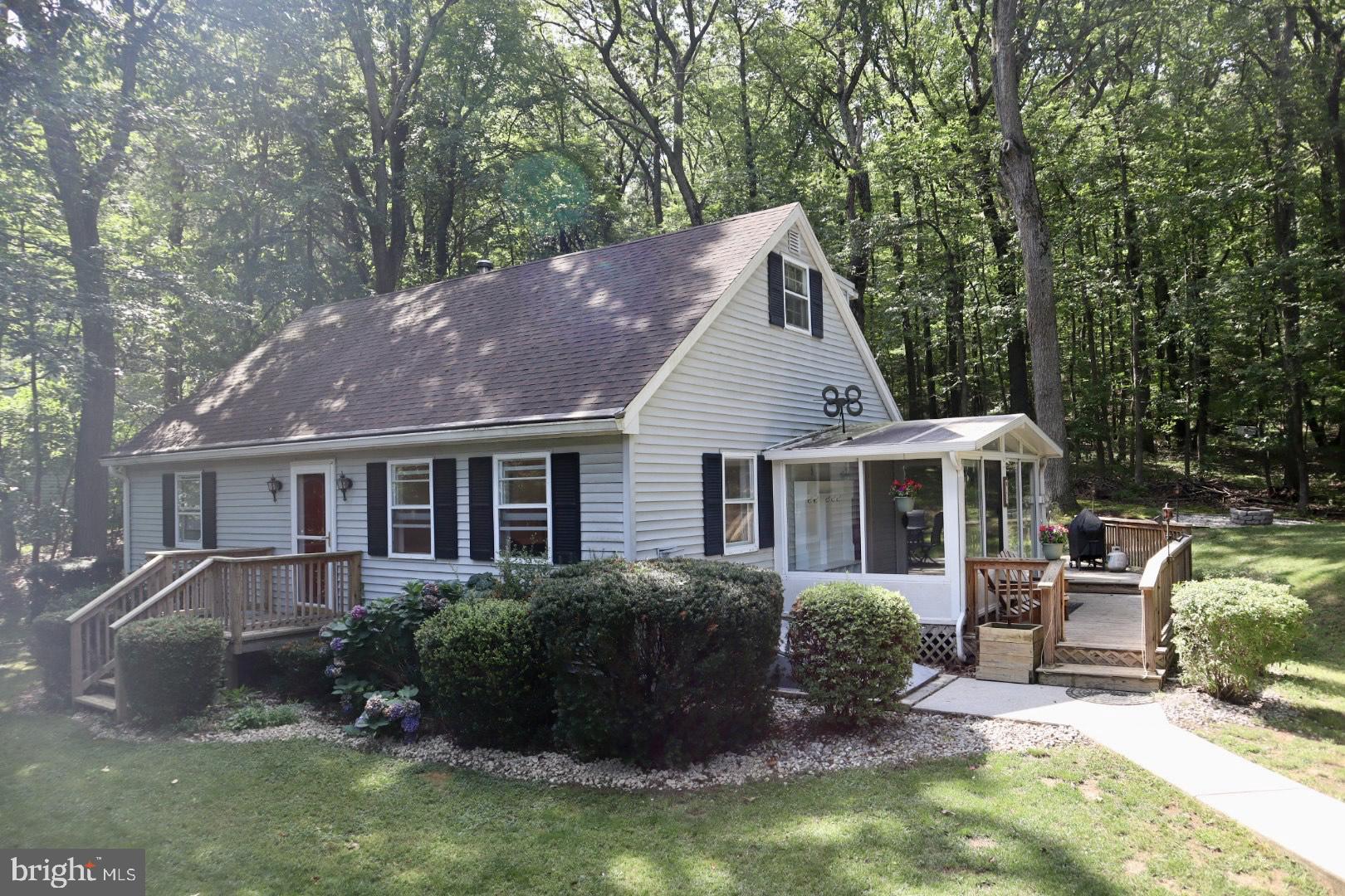 Beautifully updated home on a tree lined property with a little over an acre. Home is located in a private, wooded setting with gorgeous landscape, The large deck, complete with speakers and LED lighting is perfect for entertaining. Enjoy watching the abundant wildlife from the enclosed patio sunroom. Home has an updated kitchen with quartz countertops, new deep farmhouse sink, faucet, refrigerator, backsplash, and light fixtures. New 1st floor master bath with a walk-in shower, glass doors, stone tiled floors, linen closet, vanity, toilet, LED mirror, and light fixtures. Fresh paint throughout, new light fixtures and ceiling fans. Added railing to front door entry and a landing with stairs and railing to access the room above the garage. Also, for the car enthusiast there is a heated 2 car garage and a 24ft by 36ft pole barn. New garage door openers with Bluetooth capability. Lower level has a large family with pellet stove. Come see and Enjoy!