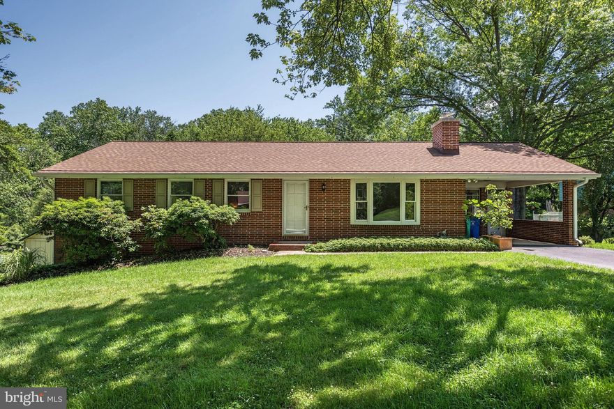 Beautifully updated all brick rancher on a quiet street in sought after Ellicott City! Gleaming hardwood floors in main level bedrooms and living areas! Kitchen features solid wood cabinets, updated fridge and access to sun porch off the carport. All bathrooms have been recently updated.  The polished concrete floors in the lower level are a show stopper! The lower level features a huge game room with fireplace, den currently used as a guest bedroom, wet bar, laundry and walkout to huge backyard and patio backing to woods. 50 year roof installed in 2017 along with new gutters.
