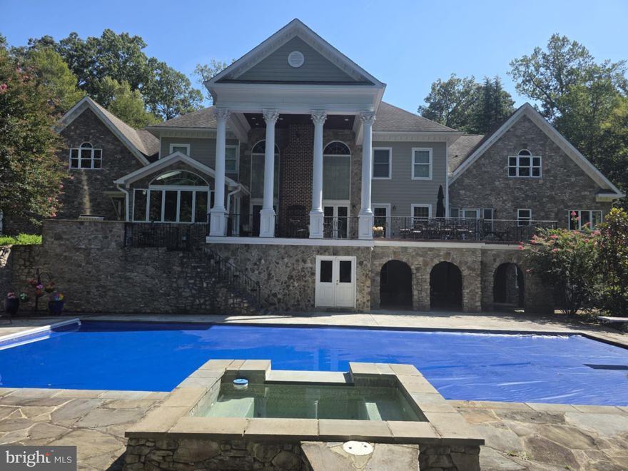 Welcome to Greek Revival architecture, a custom home designed and built by the owner, a professional engineer and architect.   A rare offering in desirable Balmoral Greens neighborhood, offering refined entertaining and everyday luxury.   Nestled at the end of a quiet cul-de-sac, this extraordinary estate offers 12,000 square feet, a four-car attached garage and a two-car detached carriage house with unfinished apartment space above the garage, on 2.4 private acres backing to protected parkland.
The stately home features 6 spacious bedrooms, 7 full baths, and 2 half baths, including a luxurious main-level primary suite and a second upper-level primary suite ideal for multigenerational living.   Soaring ceilings, exquisite millwork, and sophisticated architectural details define the interiors, highlighted by dramatic stairs, the two-story family room with coffered, ornate ceilings and walls of windows overlooking the grounds.
The lower level boasts a beautiful large bar area with wine cellar, a sitting area that leads to the game room, a theater with bi-level seating for eight, an office, an exercise room with adjacent unfinished space perfect for a sauna as well as direct access to a full bath, and a bright spacious room with walls of windows, perfect for a wellness retreat or yoga studio. 
Designed to inspire, the home also offers expansive unfinished attic spaces on both sides of the residence with high ceilings—an exceptional opportunity to create additional bedrooms, offices, or any custom space envisioned by the next owner.
Outdoor living and entertaining at its best, featuring a grand covered terrace overlooking the oversized pool,  and a charming stone pool house with a full bath, a changing room,  kitchen, and covered patio with a wood burning fireplace overlooking the spa.  All these, surrounded by  beautifully landscaped grounds, the endless parkland with mature trees, with access to the Johnny Moore Creek, located a few yards from the perimeter of the property, creating a private resort-like setting. 
Perfectly positioned within one of Northern Virginia’s most coveted communities, residents enjoy direct access to over 17 miles of scenic trails for hiking, horseback riding, and nature walks, proximity to Westfields Golf Club and the charming town of Clifton which offers acclaimed dining, wine tasting, cafés, boutique shopping and community events.
Offering a rare combination of privacy, natural beauty, and accessibility, this exceptional estate provides a tranquil suburban sanctuary, with convenient access to major routes, including Routes 28, 29, I-66, Braddock Road and Fairfax County Parkway.