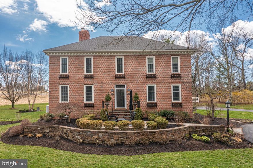Welcoming you at the top of a picturesque drive is this exceptional all-brick Georgian style manor nestled on over 4 acres with spectacular panoramic views of Upper Makefield.  This 5-bedroom, 4.5 bath center hall masterpiece offers expert craftmanship with perfect consideration to detail throughout. The exterior of this home presents stunning dental molding, custom wrought-iron window boxes and several courtyards highlighting bluestone and herringbone brick accents adding a flare to enhance this home’s country charm.  Just to the side and in addition to the home’s attached 2-car garage, is a complemental detached 2-car garage ornamented with carriage styled doors and storage that can be easily converted into a workshop. The picturesque, mature tree-lined grounds offer much privacy and include professional landscaping and magnificent outdoor space including a deck area complete with a soothing hot tub ideal for those cool evenings.  Inside, which is just as spectacular, boasts stunning wide plank pine flooring throughout both the first and second levels, 9 ft. ceilings, bold eye-catching moldings and several paneled walls, decorative wood staircase complete with a central landing allowing you access to both second floor wings, 3 impressive wood-burning fireplaces and custom lighting. The home’s stylish Gourmet Kitchen is a chef’s delight and offers old world charm with today’s modern conveniences with its exquisite sprawling center island, striking leather granite countertops, custom cabinetry, commercial grade appliances including a paneled Sub-Zero refrigerator, Wolf 6-burner gas stove with double oven and an adjoining breakfast sitting area with natural lighting perfect for the morning’s first cup of coffee. Adding to the ideal entertainment flow is the neighboring Dining Room that can accommodate a large family with ease and offers a beautiful custom, built-in corner cabinet accentuating this space. Within eye’s view and across the entry way sits a cozy Formal Living Room which is currently being utilized as a Study and is adorned with an attractive wood fireplace centered on a classic traditional raised panel wainscoted wall. Conveniently located in the rear of the home, is a secluded and roomy Primary Suite accessed by a private foyer and ornamented with a gorgeous marble bath and his and her walk-in closets outfitted with custom built-ins. The suite is draped with 3 walls of windows allowing for an abundance of natural lighting and breathtaking backyard views and offers access to the side deck. Completing the main level is a sitting room with connecting bonus area, family room, drop zone with laundry closet, half bath and garage access. The upstairs is just as inspiring with its floor-to ceiling bookcases and window seating nook. Two spacious En-suite bedrooms, linen closet and hallway bath centered between 2 additional sizeable bedrooms complete this level. Enjoy a workout, play space, media room or utilize the amazing finished space on the lower level of the home as desired.  Additional amenities include a state-of-the-art water filtration system, generator, security cameras, views of Jericho Mountain and Council Rock schools. Come explore this hidden treasure located minutes away from historic Newtown, the Delaware River and the I-295 corridor for easy commuting.