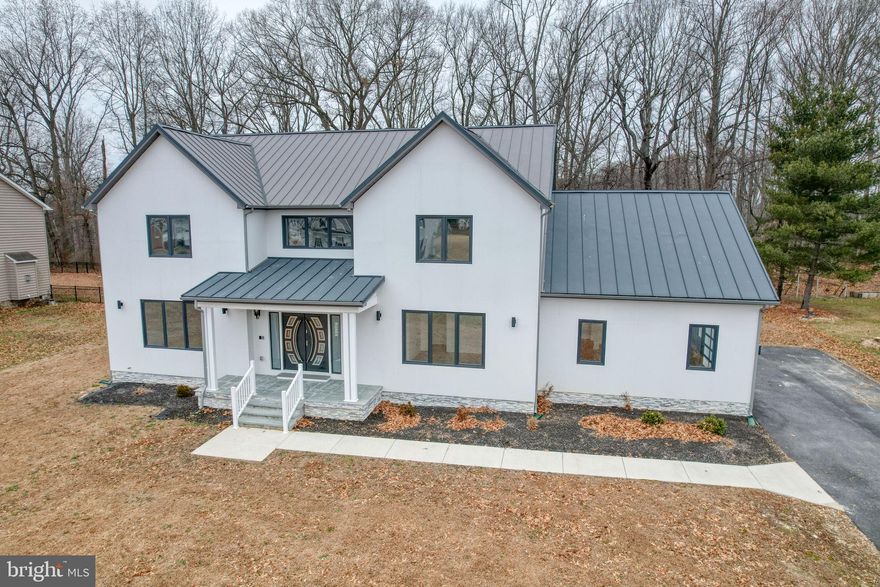 This impressive new construction home blends ultra-modern design with a warm, inviting layout, offering nearly 4200 square feet of finished living space across two levels. The open main level is filled with abundant windows, allowing natural light to pour in throughout the day and highlighting the home’s clean lines and spacious design. At the heart of the home is a crisp, light-filled kitchen featuring plentiful cabinetry, sleek countertops, a massive walk-in pantry, and an adjacent mudroom for everyday convenience. The kitchen opens effortlessly to two eating areas and the expansive great room, where a gas fireplace provides a welcoming focal point. A formal living room adds flexibility for entertaining or quiet relaxation.
The main level also offers a private bedroom with a full ensuite bath—ideal for guests, multigenerational living, or a home office. Upstairs, four generously sized bedrooms are paired with three full bathrooms and a conveniently located laundry room, creating a layout designed for both comfort and ease.
The unfinished lower level is exceptionally large and ready to be customized to suit your needs. Outdoors, a deck overlooks a private, wooded backyard, offering a peaceful extension of the living space.
Located in the Caesar Rodney School District, this home combines modern architecture, thoughtful design, and impressive scale—truly a rare offering and unlike anything else currently available. Schedule your tour!