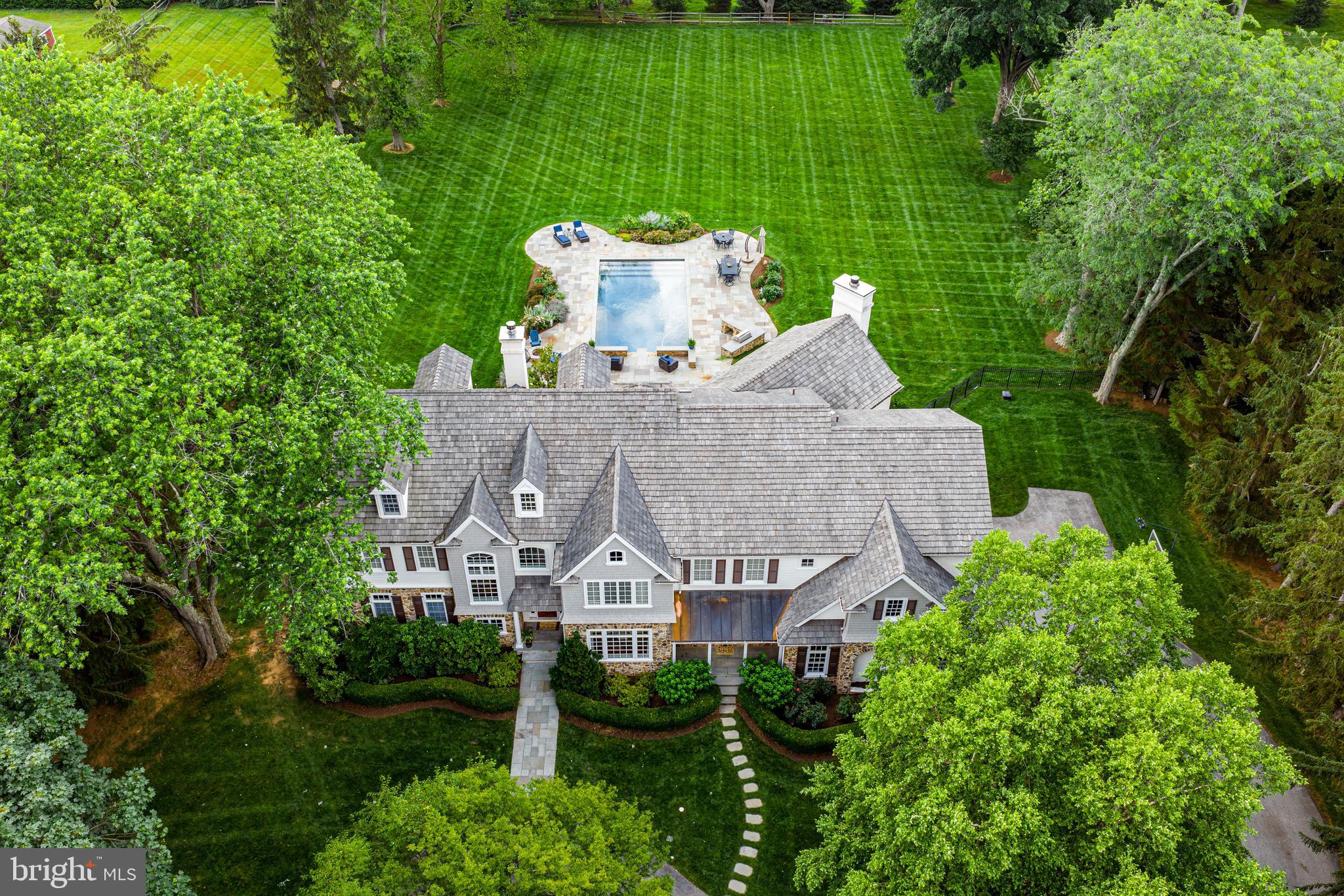 3537 Sawmill Rd, Newtown Sq | Aronimink Golf Club Views | PHOTOS Mon
An extraordinary opportunity to own a refined, resort-style residence with breathtaking views of Aronimink Golf Club—host of the 2026 PGA Championship. Designed by architect Peter Batchelor and built in 2006, this 5-bedroom, 5 full and 2 half-bath estate home sits on nearly 2 beautifully landscaped acres with a stunning pool, multi-tiered terraces, and the privilege of overlooking Aronimink’s iconic 4th Fairway.
From the moment you arrive, this grand yet timeless home captivates with its architectural presence. A sweeping circular drive leads to a sunlit interior with soaring ceilings, Hardwood floors, extensive millwork, and golf course views from nearly every room. Freshly painted in soft neutrals, the home offers a warm and elegant feel throughout.
At the heart of the home is a spectacular, professionally reimagined Kitchen designed with custom white cabinetry, double-thick leathered granite countertops and backsplash, a Wolf 6-burner range, convection wall oven and microwave, two dishwashers, and a 48” SubZero refrigerator. The vaulted Breakfast Room is wrapped in windows dressed with designer drapery and opens to panoramic views of the backyard, pool, and fairways. Adjacent, a fully renovated Butler’s Pantry echoes the kitchen’s luxury design with herringbone tile, wine fridge, sink, dishwasher, and cabinetry—perfect for effortless entertaining.
The dramatic two-story Great Room features vaulted ceilings with a statement chandelier, a wood-burning fireplace framed by custom paneling and windows, and two sets of sliding doors opening to a bluestone terrace. The Formal Dining Room and Living Room—w/ tray ceiling, gas fireplace, and more rear-facing windows—offer space for both grand entertaining and everyday living. A charming Sitting Room and a private Home Office add comfort and versatility. A second Powder Room, walk-in Pantry, Mudroom with built-ins, and access to the 3-car garage complete the main level.
Upstairs, the recently renovated Primary Suite showcases exceptional design by professional interior designers. This serene retreat includes a Sitting Room with electric fireplace, custom walk-in closet, and spectacular views of the golf course and sunsets. The spa-style Bath is a showstopper w/ dual vanities, soaking tub, large shower, private water closet, designer tile, custom cabinetry, and elegant lighting. Bedroom 2 is ensuite; Bedrooms 3 and 4 share a Jack & Jill bath w/ separate vanities and private tub/toilet room; Bedroom 5 also features an ensuite bath. A spacious Laundry Room w/ built-ins and skylight completes the level.
The finished third floor provides significant flexible space for a playroom, study area and more. The daylight, walk-out Lower Level includes a Recreation Room, Gym, Media Area, full Bath w/ shower, and storage—and opens to the rear terrace for seamless indoor-outdoor living.
Approx. Finished Sq Ft:,
6,565 sq ft above grade (main + 2nd floors)
1,400± sq ft finished 3rd floor
1,800± sq ft daylight Lower Level
Total: 10,600+ finished sq ft
Outdoor living is especially impressive: a lush, level, private rear lawn surrounds the resort-style pool, upgraded hardscaping, and multi-level bluestone terraces accented by low stone sitting walls capped in Bluestone. Manicured gardens and a combination of split rail and wrought iron fencing frame the space, enhancing both beauty and privacy. From your patio or expansive windows, enjoy unforgettable sunsets and a front-row seat to Aronimink’s 4th of July and New Year’s Eve fireworks displays.
Located in an unbeatable location—just 1 mile to Episcopal Academy, 4 miles to Berwyn & Wayne train stations, and minutes to Main Line dining, shopping, top-rated schools, and major routes.
A one-of-a-kind residence offering timeless elegance and unobstructed views of one of the country’s most prestigious golf courses—Now this is Main Line living!!