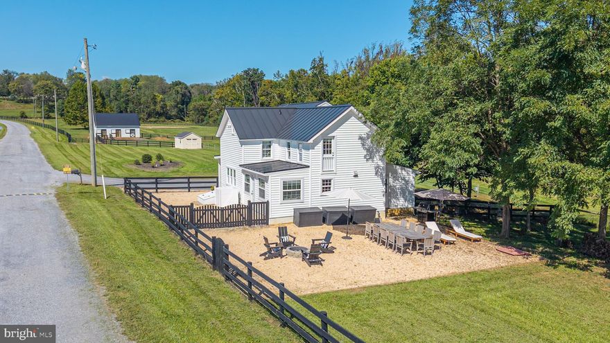 Turn-key, rarely available equestrian property with restored and expanded farmhouse, 4-stall barn, and riding arena on 16 acres with Fios high-speed internet in sought-after Leesburg, Loudoun County. This unique property features a meticulously restored interior that preserves historic character while offering modern systems and a 3-car garage. With quick access to downtown historic Leesburg, Lovettsville, the MARC Train, and the Dulles Greenway, it delivers a complete equestrian lifestyle combined with the convenience of connectivity for work or study from home.
The equestrian amenities are thoughtfully designed and highly functional. The Amish-built 4-stall barn features four 10 x 12 stalls with a center aisle that allows excellent ventilation, keeping the barn cool in summer, while the sturdy construction maintains warmth in winter. The barn includes a wash and grooming stall, a heated tack room, and interior stairs to the hayloft that holds 400 square hay bales and room for extra storage. An 80 x 120 sand and bluestone riding ring is just steps from the barn, ideal for daily training. The property has four fenced paddocks for turnout. An expansive rear field allows for galloping and cross-country schooling without leaving the property or future additional turn out. Additional structures include a large run-in shed and a tractor shed. There is excellent room for horse trailer parking and easy access for your farrier and vet.
A classic farmhouse front porch extends across the front of the home, offering a welcoming and authentic farmhouse entry. Inside, the original farmhouse features a living room with exposed beams overhead and heart pine floors showcase the surprisingly scaled dining room that comfortably seats 12. The gourmet kitchen is designed for the serious cook with a six-burner dual-fuel range, a large quartz island with seating for five, a farmhouse sink, round mosaic backsplash, and generous cabinetry.  A nearby cozy sunroom is the perfect spot for daily meals. Beyond the kitchen, an expansive fenced pea-gravel rear entertaining area provides an ideal setting for outdoor dining or gatherings while overlooking the horses in the pastures.
Upstairs in the original farmhouse, the primary suite offers two walk-in closets and a charming bath with clawfoot tub and separate shower, creating a private and elegant retreat. The second ensuite bedroom, currently used as a home office, adds flexibility for guests or work-from-home needs.
The expanded addition above the 3-car garage seamlessly complements the farmhouse, offering distinct and private living spaces including two additional bedrooms, a full bath, a family room, and a den. The layout provides a balance of connection and privacy, ideal for family members or guests. An ultra-expansive mudroom sits between the two wings, with a conveniently located half bath nearby, keeping daily life organized and practical. Windows throughout both areas fill the home with natural light and offer serene views of the pastures
When you are not riding the walking trail along the creek offers a great spot to exercise the dog.  Wildlife is abundant, including bald eagles, red-tailed hawks, deer, fox, and Blue Herons. Located off paved Loyalty Road with nearby amenities including vineyards, breweries, antique shops, golf, and quick access to the Potomac River. Premier equestrian venues such as Morven Park, Loch Moy, Upperville Horse Show Grounds, and the Marion duPont Scott Equine Medical Center are just minutes away, enhancing the equestrian lifestyle this property provides.
This is a rare opportunity to own a turnkey equestrian property in a prime Loudoun County location, with meticulously preserved historic charm, modern living systems, unique layout, and exceptional horse facilities. Very small and mild country HOA -17 homes.