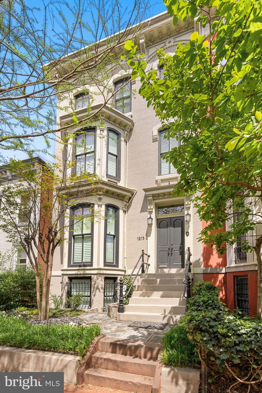 Welcome to this grande dame of Logan Circle.  Timeless architecture meets modern functionality in an expansive, beautifully renovated layout. Spanning four finished levels and over 3,500 square feet, this home offers a seamless blend of historic elegance and contemporary comfort. Entering through the marble foyer, you're greeted by an inviting main level with high 11-foot ceilings, creating an open, welcoming atmosphere that flows effortlessly from one room to the next.

The spacious living area, warmed by one of the home’s eight fireplaces, and beautiful built-in shelving and cabinets, invites relaxation and conversation. An elegant entry leads you to the large formal dining room, complete with a dumbwaiter and original heart of pine hardwood flooring. Floor to ceiling windows and access to the private dining balcony overlooking the lower level patio completes this floor, perfect for entertaining. Nearby, the gourmet kitchen—complete with stainless steel appliances, granite countertops, and a generously proportioned area for casual dining—ensures effortless transitions from cooking to entertaining.

The upper floors house generously proportioned private quarters. Four spacious bedrooms, including a uniquely soundproofed primary suite, provide comfort, privacy, and flexible options for guests, home office space, or hobbies. Light pours in from an extra-large custom-designed and fabricated skylight.  The upper floors also offer two separate Lounge or sitting areas, and access to yet another private balcony, creating a bright and welcoming atmosphere throughout. Thoughtful renovations, including special noise-reducing windows, designer finishes, electric window shades, and beautiful plantation shutters ensure that the home remains a peaceful sanctuary amid city life.

Step outside to enjoy a perfectly manicured garden oasis, complete with lush plantings, a tranquil fountain, gas fireplace and built-in seating, and ample space for relaxation. With meticulously designed decks and covered outdoor areas, the home’s exterior spaces feel like a private country retreat—perfect for a quiet glass of wine or hosting large gatherings. The main level and outdoor spaces can easily accommodate events of 100+ guests, with formal living and dining rooms and parking large enough for two SUVs providing convenience for hosts and visitors alike.

With its unbeatable proximity to Logan Circle, 14th Street, 9th Street and K Street/downtown, this home offers both peaceful retreat and vibrant city life -- acclaimed dining, Whole Foods, gyms, retail shops, and the Convention Center are all within minutes walking distance!  

No expense was spared nor detail overlooked during renovations.  Entering this home immediately provides elegance, comfort and calm -- in the middle of Washington's most vibrant and desirable neighborhood.