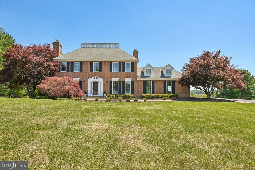 Stately brick colonial positioned on a beautifully landscaped lot with Million-Dollar Views and exceptional outdoor living spaces. This well-maintained home blends timeless architecture with spacious interiors designed for both everyday living and entertaining. Inside, you’ll find elegant crown molding, hardwood flooring, generous room sizes, and abundant natural light throughout. The inviting living room with fireplace and dining room flow seamlessly into a spacious kitchen with ample cabinetry, stainless steel appliances, center peninsula seating, and scenic backyard views. A cozy family room with a fireplace and French doors opens directly to the expansive rear deck, creating effortless indoor-outdoor living. Upstairs, the primary suite offers a private retreat complete with sitting area, fireplace, walk-in closet, private balcony access, and panoramic views of the surrounding landscape. The upstairs also includes additional secondary bedrooms that are generously spacious and offer some of the best views of the property. The finished walk-out lower level adds exceptional versatility with a large recreation area, stone fireplace, wet bar/kitchenette, fitness space, full bath, and direct patio access. The lower level also doubles as an in-law suite that is complete with a kitchenette and a private entry. Whether hosting guests, creating a game room, or designing a private retreat, the possibilities are endless. Outside, the property truly shines with an oversized maintenance-friendly deck with Ironwood boards, an elevated gazebo, hot tub area, multiple entertaining spaces, and expansive open lawn framed by mature trees, a large storage shed with a loft, and picturesque views. The original owners spared no expense as they finished the attic with easy access to additional storage space as well as finishing the garage floor with epoxy. From quiet mornings overlooking rolling green space to evenings spent entertaining under the stars, this property offers a rare combination of privacy, space, and classic elegance while being located in the premier area of Montgomery County.