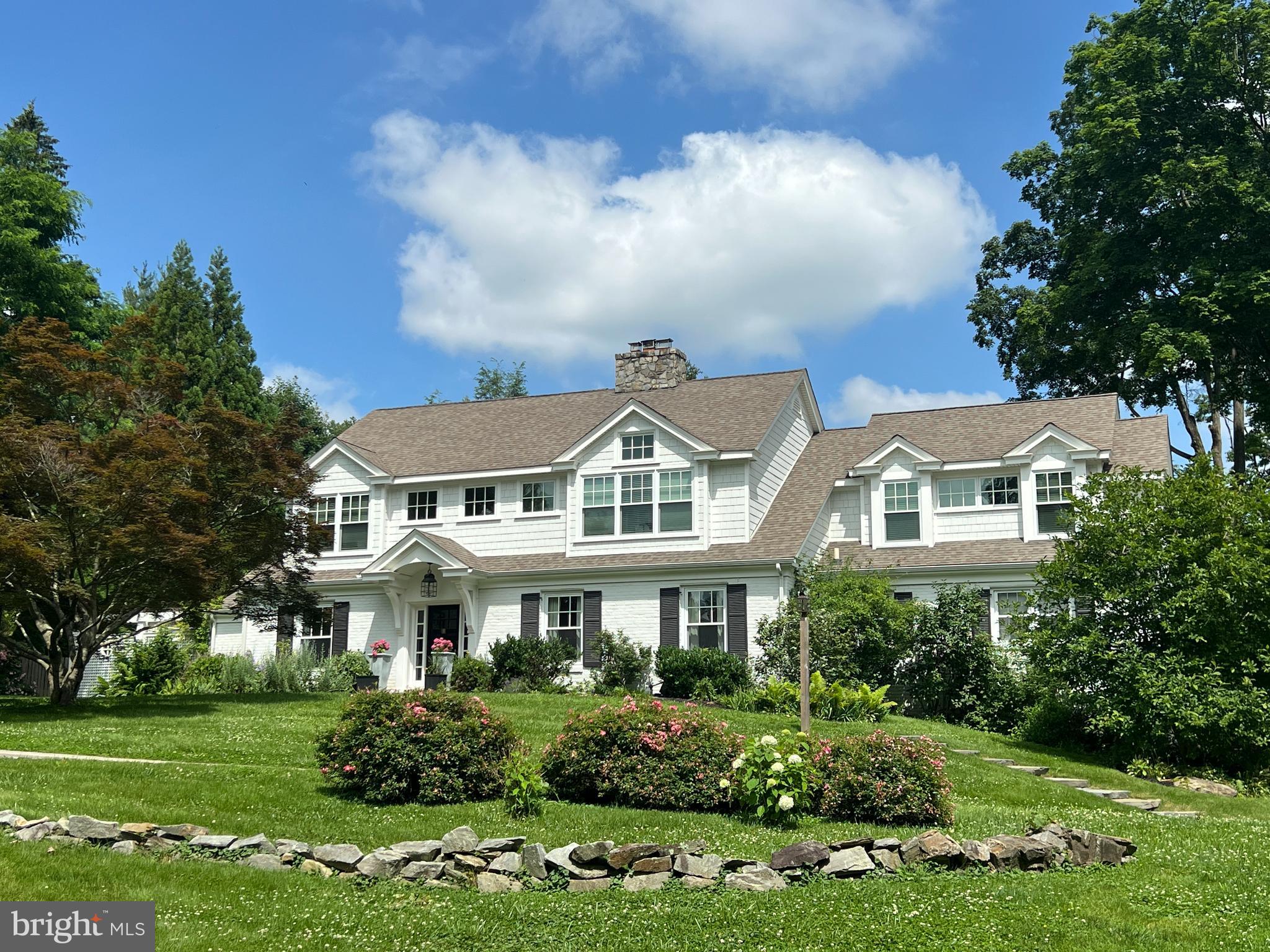 Quintessential and oozing with style, this New England Colonial is set on a hill and has a quiet and completely private 1 acre lot with a stunning pool and multiple enchanting outdoor entertaining spaces. This flexible floor plan allows for 5-7 bedrooms or 5 bedrooms and his & hers offices. The private first floor wing could also be used as an in-law or au-pair suite. There are 3 full baths and one main level powder room. Retreat to your gorgeous primary suite upstairs with a dramatic vaulted ceiling, custom beams and spa like primary bath with a top of the line Kohler vibrcoustic soaking tub. There is a finished lower level including family room with bar, exercise room and a to die for huge 4 car garage. It is evident that this designer's own residence has been impeccably curated with attention to every space inside and out. Sure to impress.
