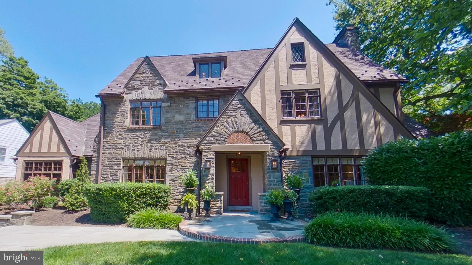 On one of the most coveted blocks in Villanova, this beautiful Tudor home has a welcoming classic and elegant presence. The flagstone and brick walkway and low stone walls with lanterns highlight the detail that this home has and lead to the columned front portico with a masonry sunburst over a herringbone design of bricks above the front door. The entry room greets you with the original architectural design bronze and wrought iron stair rail, a similarly chosen wrought iron chandelier and beautiful oak hardwood flooring. The formal living room has a wood burning fireplace with marble surround, recessed lights, in-ceiling speaker, custom shades and curtains, deep sills and french doors to the gorgeous back patio. The enclosed sunroom with stone columns, a bead board ceiling and heated travertine tile flooring is a great space to relax or work in. Being surrounded by Weather Shield windows on 3 sides it is a peaceful respite while feeling surrounded by nature. The formal dining room has brass sconces, a brass chandelier, deep window sills and custom drapes and blinds as well as crown molding. In the eat in kitchen there are custom cherry Mouser cabinets, a commercial grade range, convection oven, and a granite island and countertop. There is a walk - in pantry for extra storage just steps away. The seeded glass cabinets with lights add charm. Off the kitchen is the family room which has a 200 year old mantel from Lancaster County above the large wood burning fireplace. Decorative beams run across the ceiling of the family room adding character. Custom Mouser cabinets flank the fireplace and are also present in the bar area. There is a game table area and custom plantation shutters making it easy to darken the room and have a fun movie night. Or entertain your guests easily at the custom bar with stained glass, glass shelving, and built in refrigerator and ice maker. The floor in the family room is Turkish travertine hand cut tiles in the French pattern and is warmed by radiant heat. Outstanding stone columns highlight the entrance to the family room and are easily viewed in the kitchen. The mudroom holds the pantry and coat closet and walking to the 2 car oversized garage also allows for views of the yard with the wall of windows and French door access to the outside. The powder room has a new window and is next door to the coat closet. Walking upstairs there are built in shelves and storage at the top of the stairs and the hallway leads to the primary suite with a wood burning fireplace. In the primary bathroom there is a new window with a new Conrad motorized shade, 2 sinks, a soaking tub and glass shower. A walk in closet with built in storage is there as well. Off the primary bedroom is another walk in area for clothes and storage. Both of the 2 other bedrooms on this floor have their own bathrooms and storage. On the 3rd floor there are another 2 bedrooms that share a hall bathroom. The full basement has a climate controlled wine cellar. There are all new windows in the rear of the house, new snow guards on the roof, 2 new 75 gallon water heaters, new first floor York combination heating and air conditioning unit, new radiant floor heating controls. This impeccable home is walkable to Villanova Train Station, and the walking paths at Villanova University, and is minutes to the towns of Wayne or Bryn Mawr and close to the airport and Center City.