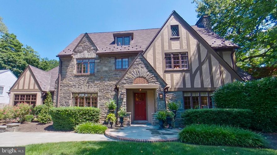 On one of the most coveted blocks in Villanova, this beautiful Tudor home has a welcoming classic and elegant presence. The flagstone and brick walkway and low stone walls with lanterns highlight the detail that this home has and lead to the columned front portico with a masonry sunburst over a herringbone design of bricks above the front door. The entry room  greets you with the original architectural design bronze and wrought iron stair rail, a similarly chosen wrought iron chandelier and beautiful oak hardwood flooring. The formal living room has a wood burning fireplace with marble surround, recessed lights, in-ceiling speaker, custom shades and  curtains, deep sills  and french doors to the gorgeous back patio. The enclosed sunroom with stone columns, a bead board ceiling and heated travertine tile flooring is a great space to relax or work in. Being surrounded by Weather Shield windows on 3 sides it is a peaceful respite while feeling surrounded by nature.  The formal dining room has brass sconces, a brass chandelier, deep window sills and custom drapes and blinds as well as crown molding. In the  eat in kitchen there are custom cherry Mouser cabinets, a commercial grade range, convection oven, and a granite island and countertop. There is a walk - in pantry for extra storage just steps away. The seeded glass cabinets with lights add charm. Off the kitchen is the family room which has a 200 year old mantel from Lancaster County above the large wood burning fireplace. Decorative beams run across the ceiling of the family room adding character. Custom Mouser cabinets flank the fireplace and are also present in the bar area. There is a game table area and custom plantation shutters making it easy to darken the room and have a fun movie night. Or entertain your guests easily at the custom bar with stained glass, glass shelving, and built in refrigerator and ice maker. The floor in the family room is Turkish travertine hand cut tiles in the French pattern and  is warmed by radiant heat. Outstanding stone columns highlight the entrance to the family room and are easily viewed in the kitchen.  The mudroom holds the pantry and coat closet and walking to the 2 car oversized garage also allows for views of the yard with the wall of windows and French door access to the outside. The powder room has a new window and is next door to the coat closet.  Walking upstairs there are built in shelves and storage at the top of the stairs and the hallway leads to the primary suite with a wood burning fireplace.  In the primary bathroom there is a new window with a new Conrad motorized shade, 2 sinks, a soaking tub and glass shower. A walk in closet with built in storage is there as well. Off the primary bedroom is another walk in area for clothes and storage. Both of the 2 other bedrooms on this floor have their own bathrooms and storage. On the 3rd floor there are another 2 bedrooms that share a hall bathroom. The full basement has a climate controlled wine cellar. There are all new windows in the rear of the house, new snow guards on the roof, 2 new 75 gallon water heaters, new first floor York combination heating and air conditioning unit, new radiant floor heating controls. This impeccable home is walkable to Villanova Train Station, and the walking paths at  Villanova University, and is minutes to the towns of Wayne or Bryn Mawr and close to the airport and Center City.