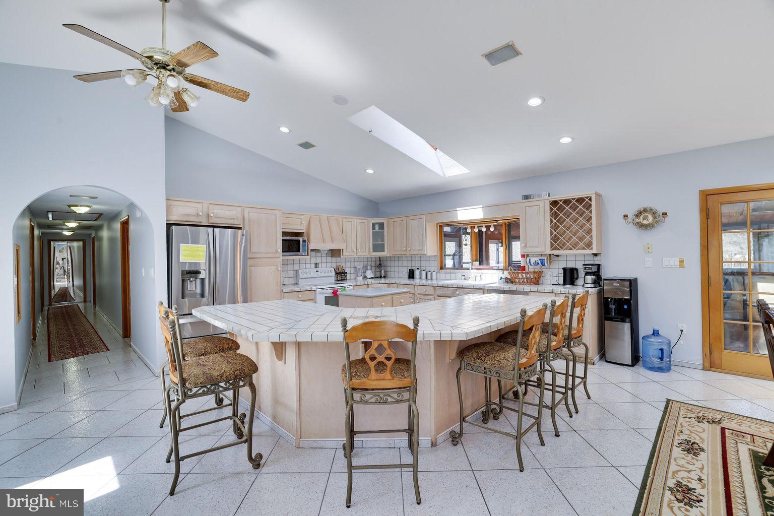Stunning oversized raised ranch is an amenity filled community is waiting for it's new owner! Welcome to your spacious 2,980 sq ft retreat, nestled on a full acre in a beautiful gated community. This home offers the perfect blend of comfort and convenience, with 24-hour security, curb-side trash pick up, five serene lakes, two pools, tennis and basketball courts, walking trails, and an active clubhouse hosting year-round events. Step inside to discover an open-concept layout featuring cathedral ceilings and a sun-drenched living room with a large bay window and stone faced wood burning fireplace. The oversized kitchen is a chef's delight, complete with an eat-in island and ample cabinet space, seamlessly flowing into the formal dining area and enclosed wrap-around sunroom—ideal for morning coffee or evening relaxation. The primary suite is a true sanctuary, boasting a luxurious marble en-suite bathroom with a jacuzzi tub, double vanity, bidet, and a walk-in closet. Two additional spacious bedrooms and additional bathroom upstairs to ensure comfort for family and guests alike. Downstairs features a family room, bonus room, game room —perfect for multigenerational living or possible in-law suite. The possibilities are endless... Outside, enjoy the expansive wrap-around deck, a paved horseshoe driveway, and a two-car attached garage. You're just a short walk from community amenities like the pool, tennis, and pickleball courts. Don't miss the opportunity to make this exceptional property your new home. Schedule a tour today!