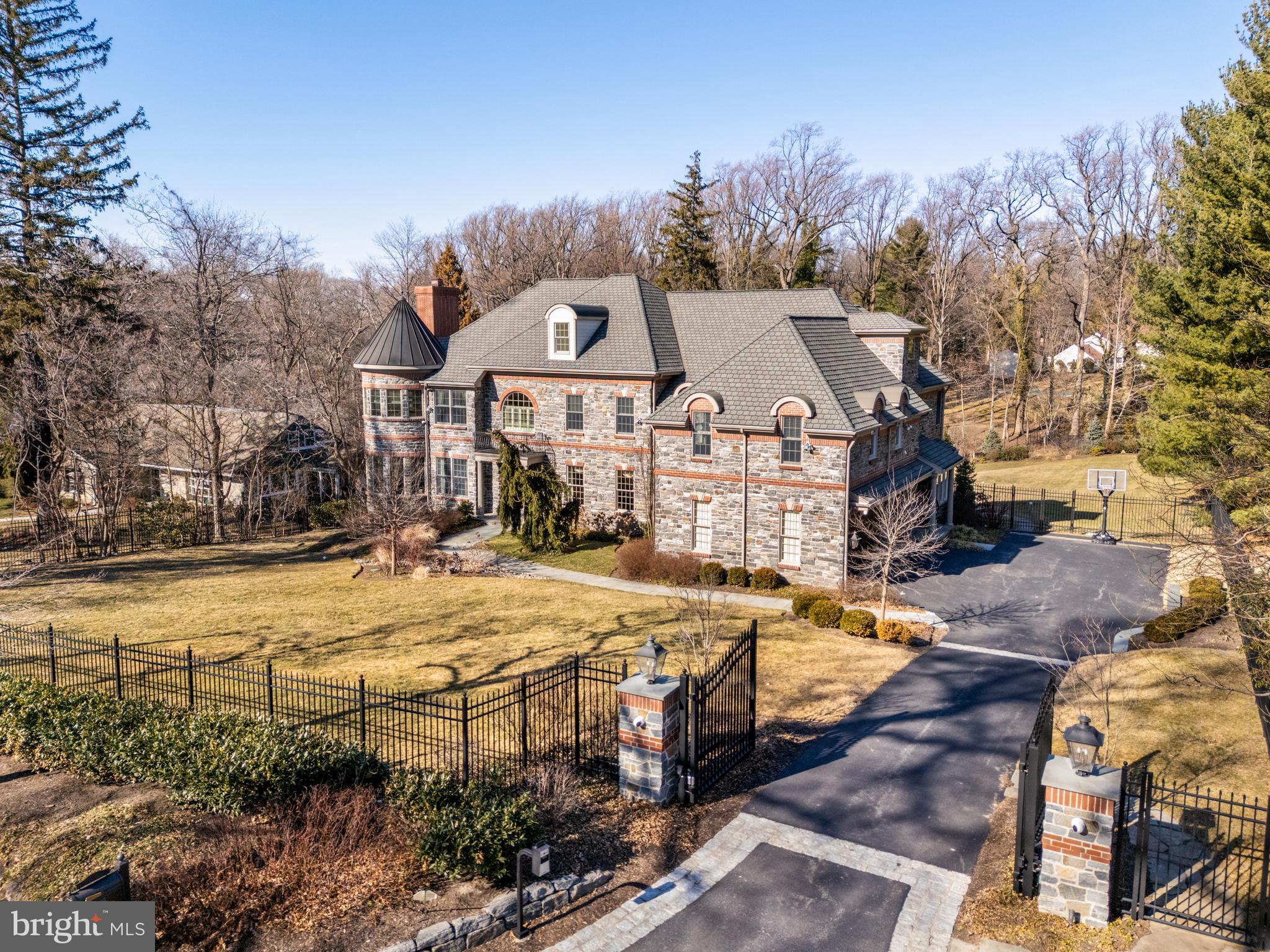 Discover the epitome of luxury living in this custom-built, gated manor home, exquisitely set on nearly an acre of lush landscaping, offering a serene and private setting. This sophisticated estate boasts impressive brick and stonework and an interior that reflects timeless elegance.
Step into the foyer, where gleaming hardwood floors, tasteful millwork and a striking turned staircase welcome you. The formal living room, adorned with a stately fireplace, and a grand dining room create the perfect ambiance for entertaining. The family room, featuring handsome coffered ceilings and a gas fireplace, is an inviting space with large windows that frame the picturesque greenery.
The gourmet kitchen, a chef’s dream, is equipped with high-end stainless-steel appliances, wine refrigerator, a large center island with breakfast bar seating, and crisp cabinetry. The seamless connection between the kitchen and family room extends to a rear stone deck overlooking the expansive grounds. The office/library, located conveniently off the foyer, offers a private retreat.
Ascend the main or rear stairs to the second story, featuring five bedrooms, three with ensuite bathrooms, a hallway bath (Jack and Jill), and a dedicated laundry room. French doors open to the luxurious primary suite and sitting room, which includes two large walk-in closets and a , sumptuous spa bathroom.
The walk-out lower level is an entertainer’s dream. The walk-out lower level is an entertainer’s dream, encompassing a large recreational area with kitchenette, wine refrigerator, and a full bath, along with a theater room for movie nights and a full gym. This home truly embodies elegance and comfort in every detail.
Floorplans of every floor can be found in the photos.
Future pool/pool house blueprints are available upon request.