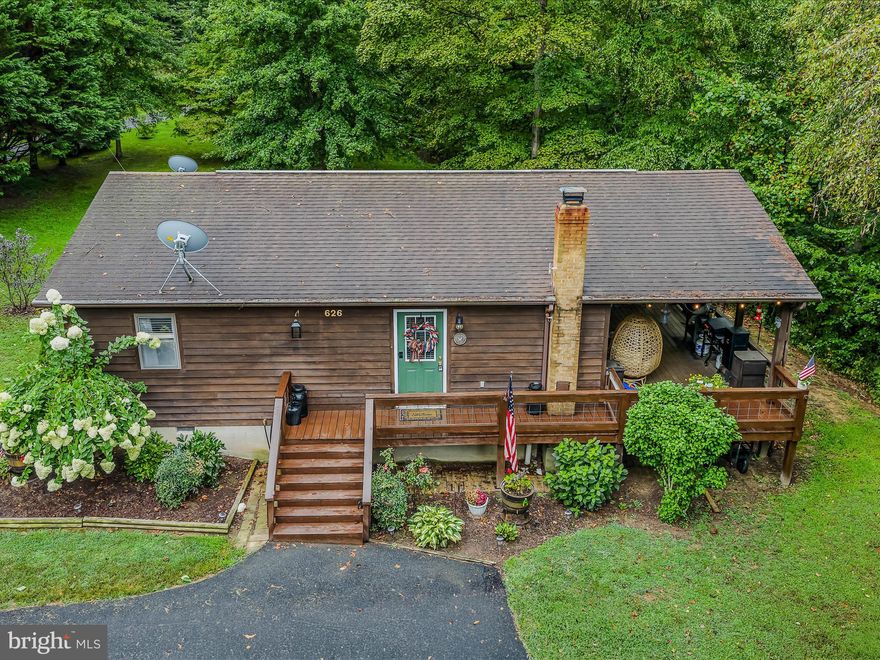 Looking for peace and quiet? This cedar-sided cabin is tucked away in the hills of West Virginia on 5.27 acres with only a few restrictions—perfect for full-time living, weekend getaways, or even hunting on your own property. The home offers 2 bedrooms, 1 bath, and an open kitchen/living/dining area, plus a 28X12 covered back porch extends your outdoor living space for enjoying the tranquil wooded setting. Three outbuildings in total provide plenty of storage, including a 24' x 30' Quonset hut steel building—ideal for a workshop, man cave, or she shed. 
Recent updates include fresh paint and stain, new appliances, a new sump pump, and a new dehumidifier. Located just minutes from public river access for swimming or kayaking and only 15 minutes from downtown Berkeley Springs, you’ll have easy access to shopping, restaurants, breweries, spas, and more. This special place offers the best of both worlds—privacy and convenience. 
Owner to find home of choice and coordinate closings.