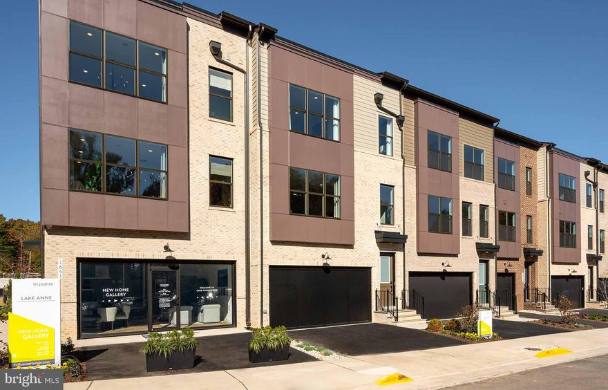 The main level blends style and comfort with a spacious dining space, center kitchen, and a bright great room featuring an electric fireplace and sliding glass doors that opens to the outdoor living. The kitchen is complete with Artisan Maple Fog cabinets, Calacatta Gold quartz countertops, Brushed Satin Nickel hardware, waterfall island, and stainless steel appliances. Upstairs, the primary suite offers plenty of space with two walk-in closets and an upgraded bath finished with quartz countertops. A laundry room sits conveniently on this level, along with a secondary bedroom that functions perfectly as a second primary suite, offering a walk-in closet and private full bath. The first floor also includes a bedroom and full bath. The home is topped off with a loft featuring a full bath and access to a private rooftop terrace. Photos shown are of a similar home.