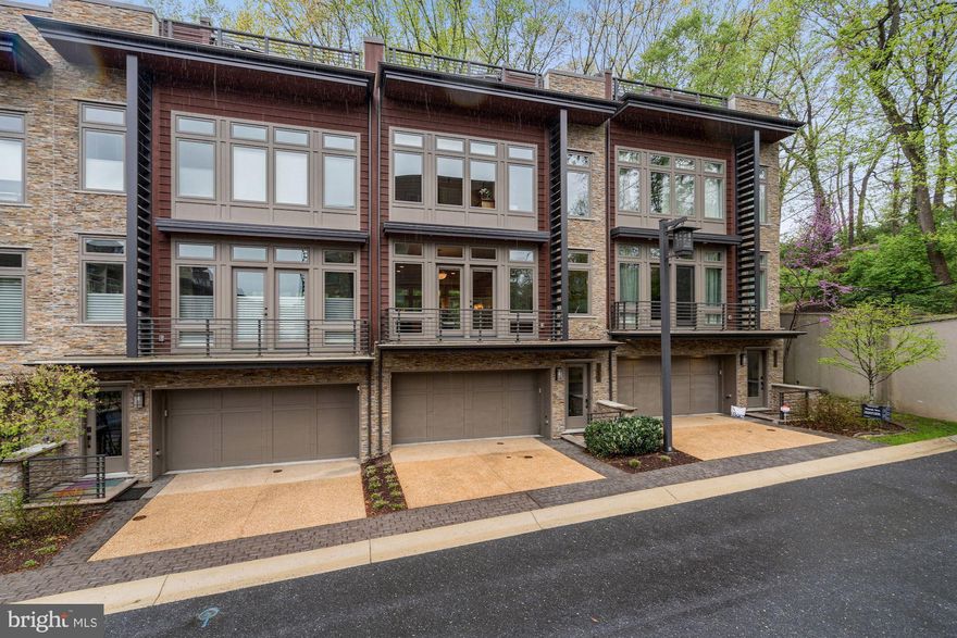 OPEN HOUSE CANCELED. Luxurious elevator townhome in popular and desirable Little Falls Place enclave backing to woodland.   An urban oasis with many upgrades and the light bright designer finishes you are looking for.  Includes a desirable enclosed garden off of the main living level as well as a chic rooftop terrace with outdoor kitchenette, fireplace (and hot tub!) offering lush verdant views of the wooded surroundings.   Enjoy an outdoor lifestyle.  Ideally located just off the Capital Crescent trail and in close proximity to both downtown Bethesda and just one stoplight to the District of Columbia.    Built ca. 2015, this like-new townhome features three bedrooms, two full baths, two powder rooms, and an office/gym/rec room and is sited to take advantage of wooded and green views through its many floor-to-ceiling windows.  Features include an elevator to all levels including the roof deck, 9ft ceilings, hardwood flooring on all levels, a gourmet kitchen, spa baths, numerous built-ins and walk-in closets, two gas fireplaces, a two-car garage with a bespoke garage storage system with a custom floor liner, a security system among others.