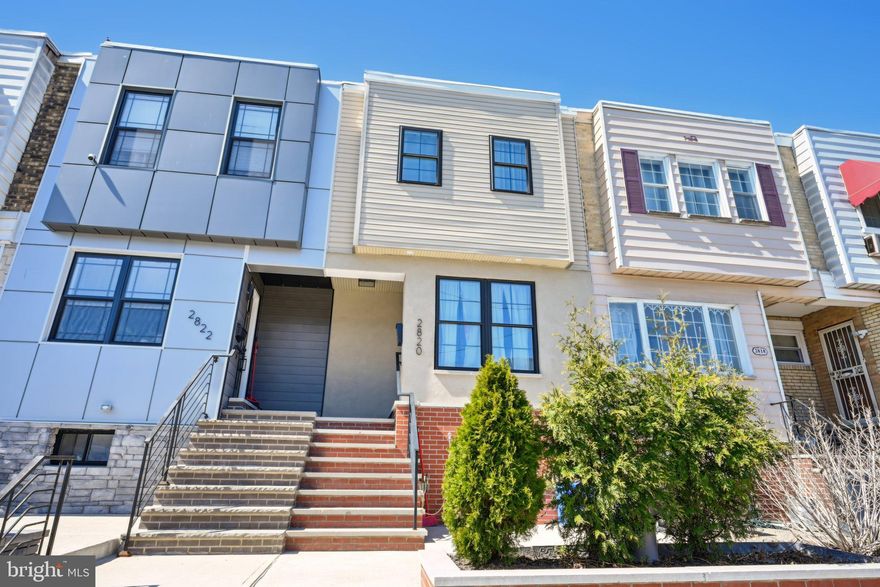 Welcome to this stunning, completely rebuilt row home in the heart of South Philly, meticulously renovated in 2022. Enter through the charming front patio into a bright and inviting open-concept main level, where gleaming hardwood floors and recessed lighting set the stage for modern living. The spacious living and dining rooms seamlessly flow into the beautifully appointed kitchen, featuring white shaker cabinets, stainless steel appliances, gas cooking, and pristine Quartz countertops. A door off the dining area leads to a lovely second-story deck, perfect for entertaining or relaxing. Upstairs, you'll find three generously sized bedrooms, including the primary bedroom at the front, all with continued hardwood floors. The full hall bathroom is a luxurious retreat with elegant tile flooring, a glass-enclosed stall shower, and a soaking tub. A skylight in the bathroom fills the space with natural light, adding to the serene atmosphere. The fully finished walk-out basement adds even more living space, with a recreation room ideal for relaxation or entertaining. A full bathroom with geometric tile flooring and a subway-tiled tub/shower combo completes this level, which also features a private rear entrance leading to the 1-car driveway. This lower level offers the flexibility to be used as a separate living unit, with its own entrance and full bathroom. Located just minutes from I-95, I-76, shopping, Live! Casino, Xfinity Live, and the sports complex, this home offers both style and convenience. Don't miss the opportunity to own this beautifully renovated gem in South Philly!