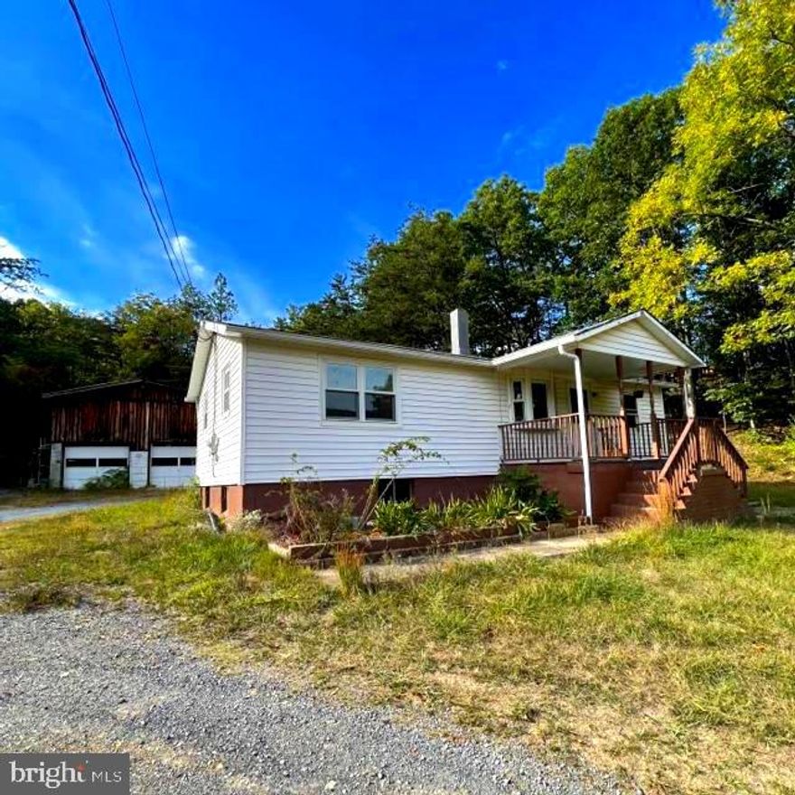 Call now to see this  ranch style home with basement and detached 3 car garage/workshop on 7/10 acre . It is just off the main road and nestled against trees with beautiful panoramic mountain views that you can enjoy from the front porch or the warmth of the living room with its bay window. The laundry room sits off of the kitchen/dining room combo and hardwood flooring runs from the living room, hallways and the 3 bedrooms.  This property also has Hardy Net internet.   Move to West Virginia and become a Mountaineer!!!