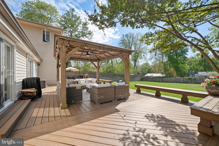 Welcome to this exceptional home, set on a quiet half-acre lot and thoughtfully expanded and renovated throughout. Blending modern updates with comfortable, everyday living, this residence offers incredible flexibility for both relaxing and entertaining—indoors and out.
The expansive main level features rich hardwood floors and a warm, inviting layout. At the heart of the home is a spacious kitchen with an oversized island and bright breakfast area—perfect for gathering with family and friends. A large dining room, cozy sitting room, and family room with fireplace and sliding doors to the backyard create multiple spaces to unwind or host with ease. The main level also includes a convenient laundry room and five generously sized bedroom suites, each with its own private bath, one of which is standout guest suite with sliding doors opens directly to the deck, offering comfort and privacy for visitors.
A unique two-story studio with a separate entrance adds even more versatility, complete with a wet bar featuring an oak countertop and an upper-level loft—ideal as a creative space, home office, guest retreat, or optional seventh bedroom. This flexible area provides endless possibilities to suit a variety of needs and lifestyles.
Upstairs, the primary suite provides a peaceful retreat, featuring a custom-designed walk-in closet and large windows that fill the space with natural light while offering beautiful, serene views. The spacious layout creates a true sense of privacy and relaxation at the end of the day.
Step outside to a very large, newly built deck with a charming gazebo, overlooking a spacious fenced backyard—perfect for outdoor dining, entertaining, or simply enjoying quiet moments in a private setting. 
The expansive yard offers plenty of room for play, gardening, or future outdoor enhancements.
Ideally located inside the Beltway, this home offers both tranquility and convenience, with easy access to major commuter routes, shopping, dining, and top-rated schools. A rare combination of space, versatility, and location, this home is truly designed to grow with you and adapt to your lifestyle.