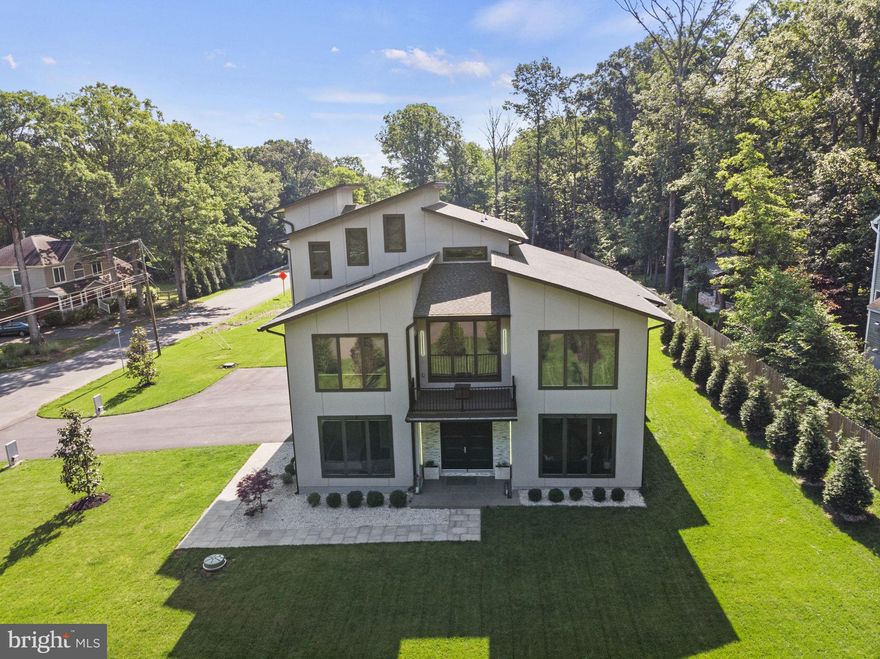 Nestled on a premium one-acre corner lot, this stunning 5 bedroom, 6 and a half bathroom, 1.5 year newly built home features an open concept design and exceptional craftsmanship with 10 foot + ceilings throughout 5400 square feet on 3 levels.  An entry level guest suite and a three-car attached garage add to the functionality and comfort of the home.  Features include  8 foot tall interior doors with a solid wood custom main door and architectural light fixtures.   The gourmet kitchen is a chef's delight, equipped with all professional grade Monogram appliances including a 48” range with hood, counter depth refrigerator, ss dishwasher and built in microwave. Venture through the family room's oversized glass sliding doors to the spacious screened in patio, perfect for unwinding and entertaining amidst a beautifully landscaped back yard complete with with green giant evergreens. The second level master features a spa-like en-suite with heated floors, double vanities, a luxurious glass-enclosed shower and standalone soaking tub.  Enjoy a convenient coffee bar, treetop views from a spacious sitting area, and an oversized walk-in closet with built-ins.   On the upper level, you'll find an entertainment space complete with a wet bar, an additional full bathroom, a balcony, and elegant vaulted ceilings.  Suitable for an adjacent secondary home, this lot offers endless possibilities for your vision.  Conveniently situated near Route 7, parks, golf clubs, Dulles airport and downtown One Loudoun’s vibrant array of shops and restaurants, this home epitomizes luxury living and accessibility.   Call and schedule your tour today!