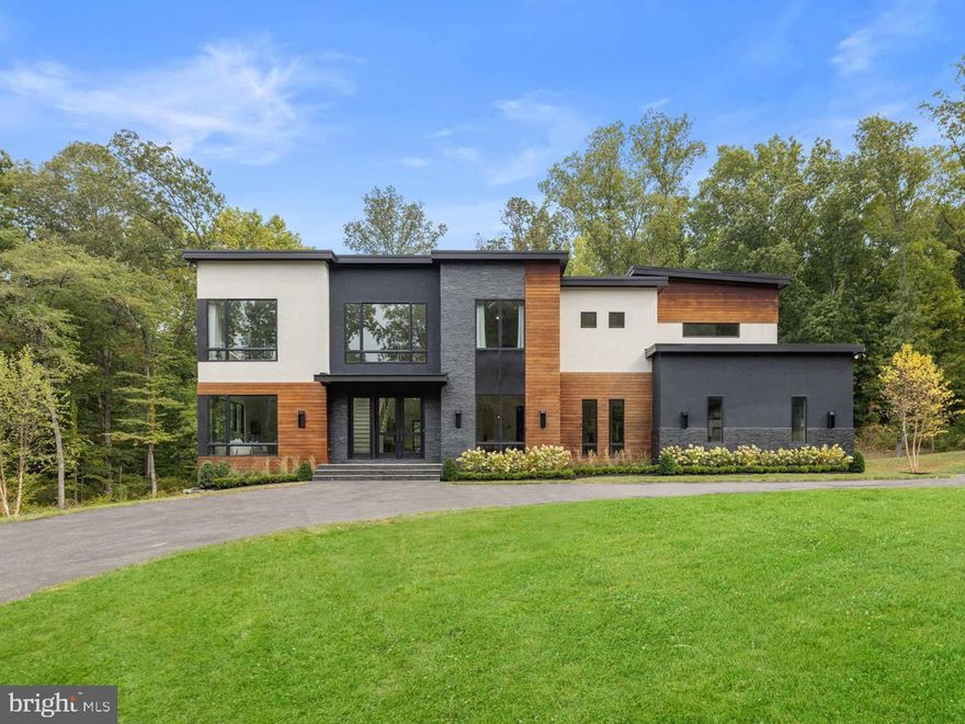 An absolute masterpiece of a home located on a private wooded 3-acre lot! Scandinavian design meets modern luxury in Loudoun County - simple, balanced, and timeless. This rare find is custom-designed to combine elements of clean minimalism with warm, open spaces enveloped by nature. 


Every corner of this home has been meticulously crafted with an eye for details. Wake up each day to larger-than-life windows in all rooms, bringing the outdoors in. Exquisite walnut wood accents complement the neutral light oak floors with contrasting dark fixtures and window frames. The overall palette against bright walls is sleek & clean yet undeniably cozy.


From the moment you arrive, experience a welcoming feel from the perfectly balanced exterior of clean lines with natural textures of stone & Brazilian hardwood. A dramatic two-story Foyer invites you directly into the bright, full-height Great Room with a 72" gas fireplace & show-stopping designer pendant light. Wide sliding glass doors lead to a future Deck/Outdoor entertaining area. 


Enjoy a wide open living space that flows into the streamlined Kitchen built with all the premium features — Quartz Waterfall Countertop & Backsplash, Custom Cabinetry & Walnut Open Shelves, Hidden Sub-Zero Side-By-Side Refrigerator, Miele Appliances including the Dishwasher, Built-in Coffee Maker, Induction Cooktop with concealed hood, Double Wall Ovens with convection & steam options. 


The airy Breakfast Nook has three walls of breathtaking windows, bringing the outside in — drenched in sunlight throughout the day. The Pantry & Mudroom/Laundry Room have garage access for a functional lifestyle. 


The Main floor has 10’ ceilings, including a private wing behind the Great Room. A spacious home Office boasting large windows & French doors faces front, with a comfortable Den/Office/Playroom space facing rear, and Powder Room tucked in between. The large staircase in the Foyer leads to all Bedrooms with a long catwalk allowing light to stream in. There are three large Bedrooms with walk-in closets, each with customized ensuite bathrooms. A private second back staircase gives easy access to the garage.


French doors open to the expansive Owner’s Suite, with sliding glass doors to a private deck - perfect for a cup of coffee or glass of wine. A double-sided gas fireplace contributes to the cozy atmosphere for both bed & bath area. Then there’s the most stunning DREAM bathroom you never knew existed! Gasp at the free-standing solid surface bathtub alongside a dreamy picture window facing the private wooded rear yard. Opposite is the zero-entry oversized frameless shower with double heads AND a rain shower! Dual skylights directly above the custom walnut vanity & floating shelves let natural light stream in all day. Two pocket doors lead to the custom walk-in closet with plenty of storage space for two. This stunning Owner’s Bathroom is actually larger than the bedroom!  


Custom built in 2020, this home is like new, with approximately 5,000 sq ft on the top two levels with 3 HVAC systems (one for every floor).

The options continue for the lower level of adding another 2,300+ sq ft, making this nearly a 7,300 sqft home with a fully finished basement. The walkout basement awaits your finishing touches with large windows & sliding glass doors. It is framed with 8.5’ ceilings for 2 bedrooms, 1 full, 1 half bath, family room, game room, movie room & bar area.   Floor plans available upon request.  This space can be fully customized to your needs.

The original plans for this home included a ground-level pool behind the home next to the LL recreation room & tennis (or pickleball) courts on the open field on the hill right next to the home. An additional 2-car garage, cabana, guest house, or anything else you can envision can be added onto this private 3-acre lot. The possibilities for the outdoor space are endless!