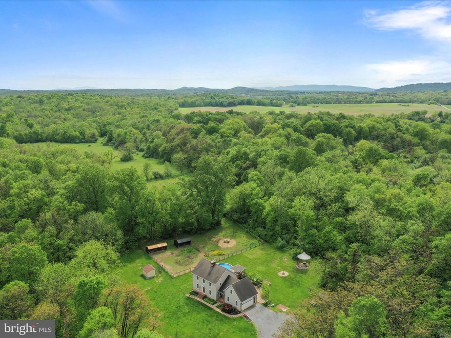 Charming Saltbox Colonial Farmette on 22.54 Acres. A private retreat with endless possibilities!

Welcome to your dream countryside escape! Nestled on over 22 picturesque acres, this classic Saltbox Colonial-style home offers the perfect blend of traditional charm, modern comforts, and farmette living. Boasting 4 spacious bedrooms and 2.5 baths, this inviting residence features stunning Brazilian cherry hardwood floors on the main level, where you'll find a cozy living room with a brick wood-burning fireplace, a separate formal dining room, and a beautifully appointed country kitchen complete with granite countertops, apron-front sink, stainless steel appliances, island, display cabinetry, and a cheerful breakfast nook.

A flexible main-level room offers endless possibilities for a den, playroom, or guest space, while a large laundry/mudroom and half bath add everyday convenience. Upstairs, the generous primary suite offers dual closets—including a walk-in—and a roomy bath with a 6-foot jetted tub / shower, and double-sink granite vanity. Three additional large bedrooms, a full hall bath, and ample storage complete the upper level. The unfinished basement offers future expansion potential and features a high-efficiency Jøtul woodstove for added warmth and charm.

Outdoor living shines here with a screened rear porch, gazebo, above-ground pool with deck, patio, and fire pit. The grounds include a unique corn crib converted into a cozy sitting area with a koi pond, three versatile sheds, raised garden beds, and private pond. Animal lovers will appreciate the fenced two-stall barn, run-in shed, and invisible fencing with collar.

This custom built home is surrouded by natural beauty, partially wooded areas, abundant wildlife, and backs to 100 acres of protected farmland.  All just minutes from the Virginia state line—perfect for commuters seeking serene living with easy access to amenities. This one-of-a-kind property offers the perfect backdrop for your country lifestyle!