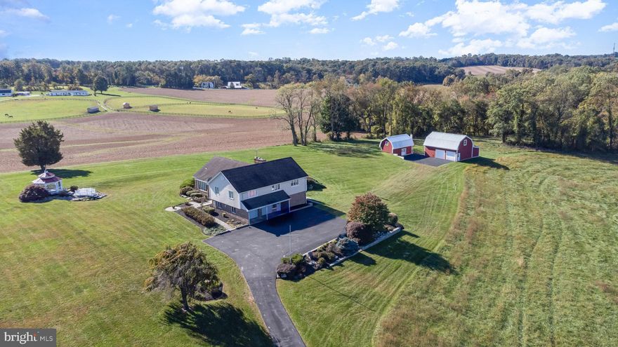 Whether you are looking for a home for your horses, livestock, classic cars or just want to be surrounded by farmland and wildlife, let me welcome you to this one-of-a-kind, custom-built farm estate nestled in White Hall.  This stunning property consisting of 4 bedrooms, 2 full & 2 half baths, and 3,295 above grade square footage, set on 14.99 picturesque acres, offers unmatched craftsmanship and breathtaking attention to detail.  Coming to the market for the 1st time, this estate seamlessly blends luxury living with the charm of countryside serenity.  From the moment you arrive, the beauty of the landscape and the meticulous design of the home will captivate your senses.  As you step through the grand double doors, the entry foyer opens into an expansive living and dining room, flooded with natural light from the expansive windows and sliding door that frame panoramic views of the stunning property. Off of the dining room is a sunroom room with a half bath that can be used a variety of ways - guest room, playroom, craft/sewing room, exercise room …  The entire main floor plan is a masterpiece featuring a combination of rich pegged hardwood floors, brick archways, and a custom stone fireplace, perfect for gathering with family and friends.  For the entertainer or culinary enthusiast, the spacious eat-in kitchen is the heart of this home.  It has three large pantries providing extraordinary storage, roomy enough to house a chest freezer, a television plus all your cooking supplies.  The kitchen’s layout is perfect for hosting, with views of the charming gazebo outside, allowing you to enjoy both intimate meals and large gatherings with ease.  On the upper level, the home boasts four oversized bedrooms and two full baths.  The primary has two generous sized closets, ensuite with shower stall and it’s own private balcony.  A special feature in another bedroom is the vanity and sink located in the walk-in closet.  Each of the bedrooms offer ample space, natural light, and serene views of the surrounding estate, making every room feel like a retreat.  Stepping down to the lower level, which is completely above ground and offers incredible views of the expansive backyard, two barns and a tranquil pond at the end of the property, you will find the perfect space for a home office.  This level also has a half bath, and a convenient laundry room complete with a laundry chute from the primary bedroom above.  The lower level leads to a spacious recreation room, complete with a pool table, piano, and refrigerator, all of which convey with the property.  Beyond the rec room, you’ll find a storage area with extensive shelving and a cedar closet.  Through the next door is a functional root cellar or wood chute with exterior access, ideal for transforming into a wine cellar.  For those who value practicality, the oversized 2 ½ car garage is a dream, featuring a workshop/mudroom, oil pit and additional storage space.  Whether you’re a hobbyist or a car enthusiast, this space is versatile and functional.  Outside, the beauty of the estate continues.  The nearly 15-acre property is a tranquil haven, perfect for horseback riding, gardening, or simply enjoying the peaceful rural landscape.  The two barns and pond further enhance the property’s charm and functionality, making it an ideal setting for creating your own country oasis.  This exclusive listing at 4208 Harford Creamery Road is a rare opportunity to own a custom-built home where luxury and nature coexist in perfect harmony.  With stunning craftsmanship, expansive living spaces, and unparalleled views from every window, this estate is more than just a home – it’s a lifestyle.  Don’t miss the chance to experience this extraordinary property.  Schedule your private tour today and discover why this exquisite estate is the perfect place to call home.