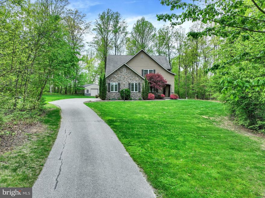 Opportunity is knocking.........A rare 13+ acre sanctuary where privacy, views, and timeless grandeur converge - Privately set on 13.06 pristine acres of wooded beauty, this stunning custom residence offers a precious opportunity to enjoy refined luxury in a breathtaking natural setting. Positioned among mature woods, with scenic views and a peaceful creek at the rear of the property, this beautiful home delivers the feeling of a secluded retreat, while remaining just minutes from everyday conveniences and major arteries. Expertly crafted by Reistville Builders, the home welcomes you with an inviting covered front porch that leads into a  2-story foyer, with a large coat closet. 9’ ceilings span the main level, enhancing the home’s sense of space, light, and understated elegance. Just off the foyer, a 1st floor office offers an ideal setting for remote working, while positioned to enjoy the calm and beauty of the surrounding landscape. At the heart of the home is an impressive great room and designer kitchen, where sleek finishes meet thoughtful function. The kitchen features granite countertops, a large center island, pantry, and stylish cabinetry, flowing effortlessly into the dining and living areas for seamless everyday living or even larger entertaining. A sliding door opens to the deck, providing serene wooded views and effortless access to outdoor entertaining, perfect for gatherings that extend naturally from the indoor living spaces. The 1st floor primary suite provides the ultimate in convenience and comfort—no stairs required. It features a walk-in closet and a luxurious bath, with a walk-in tiled shower, creating a private, easy-access retreat. A 1st floor laundry room located just off the 3-car end-load garage adds everyday functionality while maintaining the home’s polished aesthetic. The upper level offers exceptional versatility, highlighted by a second primary suite featuring elegant crown moldings, a private full bath, and walk-in closet–ideal for guests, multi-generational living, or family members who just want their own space. A bonus room connected to the suite could be used as a study, gaming room, playroom, or any other space you might want. It also has access to an unfinished attic area. Two additional bedrooms, including one with a walk-in closet, and a second full bath complete the upper level.  New carpeting was installed throughout the home just a few months ago and has remained pet-free since installation. The unfinished lower level offers abundant potential for future expansion, recreation space, or additional living areas. Beyond the home itself, the property continues to impress with a detached 24’ x 32’ pole building equipped with electric and a wood stove, providing space for additional vehicles, workshop use, or storing recreational TOYS and equipment. Surrounded by the beauty of untouched nature, towering trees, and scenic views, this remarkable residence offers the ultimate balance of elevated luxury, privacy, and serenity. It’s a place where you can truly feel away from the world while still connected to everything you need. Property is enrolled in Clean & Green.  AGENTS - Please read Agent Remarks.