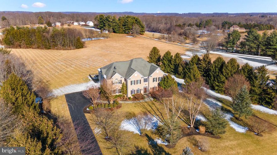 Rare opportunity to own a showstopping custom built home on a picturesque five-acre lot! This brick beauty boasts 5BR/4.5BA exudes quality craftsmanship! The floor plan boasts over 9,000 square feet of living area on three levels including over 6,000 square feet above grade. Designer-home appeal including lots of natural light, high ceilings throughout, multiple coffered ceilings, gleaming hardwoods, elaborate multi-piece moldings, and recessed lighting throughout the home. Grand two-story foyer with columns; formal living room and dining room; double glass door entry to main level study/home office; two-story great room with ceiling fan and flagstone gas fireplace with stone hearth; gourmet chef’s kitchen with center island, farmhouse sink, breakfast bar, granite countertops, wood cabinets (some with glass doors), and stainless-steel appliances; breakfast room with ceramic tile floors and wall of windows; spacious mudroom off the kitchen with washer/dryer, built-ins, and access to three-car garage. Upper-level features owner’s suite with gas fireplace, sitting room/office with recessed lighting and built-in cabinets/shelves; luxurious spa-like owner’s bath with two separate vanities, ceramic tile shower with bench seat and glass enclosure, soaking tub with tile tub deck, separate water closet, and walk-in closet; plus, three additional bedrooms and two full baths complete the upper level. Finished walkout lower level with carpeting and recessed lighting throughout; recreation room featuring a full-size flagstone bar with sink; fifth bedroom and ceramic tile full bath; bonus room; storage room; walkout to amazing and private backyard with in-ground swimming pool. Spacious deck overlooks the private lot! Only one owner has meticulously maintained this gorgeous designer home. Act now because a home like this does not come along very often!