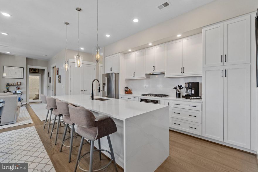 Incredible Opportunity to Purchase a 2 BR / 2 BA 1,541 sq. ft. Condo with Den, Oversized One Car Garage and Every Builder Upgrade imaginable in King Street Condominiums Community with very easy proximity to everything downtown Leesburg has to offer! Property was built by revered Knutson Companies builder in 2021 and condo was styled by interior designer to choose all high end features, meaning it is renovated beautifully and to the nines! Upon entry to the condo, you are met by open concept living, dining and kitchen combination floorplan with wide plank hardwood flooring throughout.  Kitchen boasts marble counters, including on waterfall style expanded island, 42 inch white cabinets, pantry storage, high end stainless appliances, expanded stainless wash sink and custom backsplash.  Living / Dining room area with custom light fixtures, custom fit area rugs, stylish ceiling fan and gas fireplace.  Off the living area is huge balcony, perfect for your morning coffee and weekend exterior entertaining space.  Primary bedroom also with wide plank hardwood floors, custom ceiling fan and huge walk-in closet with closet storage system.  Primary bathroom with floor to ceiling tile herringbone pattern step-in shower, tile flooring, walnut vanity, quartz counters and toilet bidet.  Second bedroom on opposite side of condo with walk-in closet, second closet for storage and custom ceiling fan. Second bathroom also with herringbone tile pattern tub shower combo and walnut vanity with quartz counters. Den is currently appointed as a gym and office combination and has study shelving, making it an ideal space to work from home.  Additional Storage Room with Large Stackable Washer/Dryer, with shelving system for even more storage.  Entire property is equipped with motorized window treatments and all rooms are hardwired for cable and internet. Independent to condo One Car Garage on first floor of building, with one oversized space and extra custom storage. Driveway parking can be used for second spot / tandem parking and there is plenty of extra guest parking in the community.  Building is secured by 24 hour access fob and condo has video intercom system for all visitors who enter through the callbox at secured main door of building. Development is located adjacent to the W&OD Trail, local parks and has quick access to all restaurants, shopping, breweries and coffee shops in downtown Leesburg, including The Lightfoot, Tuscarora Mill, Crooked Run, Goose Cup and Others.  Upscale Hotel 'Burg with luxury Hunton Restaurant is now open and around the corner from the condo. ***Pictures are from previous listing, but property is still immaculate***. Do not miss this amazing opportunity!