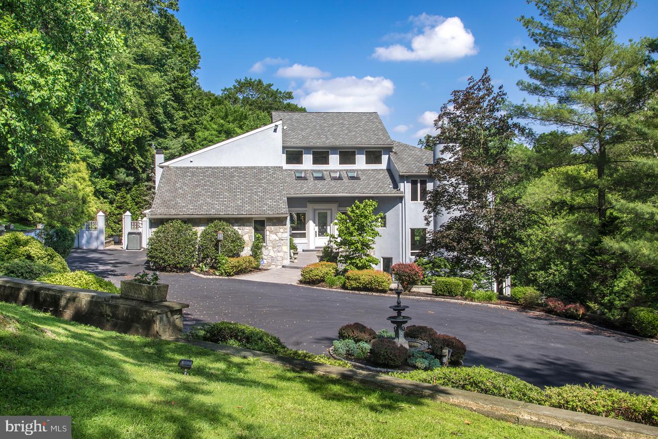 Modern elegance is in full display in this exceptional 5 bedroom, 7.1 bath residence in prime Gladwyne, set amidst 3 private landscaped and wooded acres in the Main Line s coveted Northside Mill Creek region. The experience begins with a long winding gated drive that proceeds through stunning grounds to a large circular drive, covered carport, and 5-car attached garage. A fabulous outdoor patio, 39 x18 pool, regulation-size tennis court, and multi-tiered terraces round out the resort-like ambiance of this contemporary gem and ultimate family oasis. The front door opens to a sensational 2 1/2-story entry hall/gallery awaits, likening a modern art museum with soaring ceilings and expansive wall space for displaying artworks. Marble floors, a striking curved staircase, drop chandelier, and generous windows and skylights further dramatize this impressive space. The main level is designed for living and entertaining at its best. The gracious floorplan is highlighted by airy ceilings, wood and marble flooring, and generous glass inviting abundant natural light. Beautiful nature views are enjoyed all year round, from every vantage point. A spacious living room, dining room and family room set a tone of comfortable elegance for hosting and relaxation. The sleek, striking kitchen is fully equipped for the cook with granite counters and premium Miele appliances, with an open breakfast room, soaring ceilings and massive window wall bringing the outdoors in. On the second floor, an expansive master bedroom suite with a fireside sitting area, dressing room, and deluxe marble-clad spa bath provides a serene retreat. Three additional large bedrooms - one with a loft space, all with en-suite baths and ample closets - provide private quarters for family and visitors. An office/library features lovely built-ins and elevated views. The full, finished lower level boasts multiple entertainment areas, a bar, dance floor, family room, plus an office area and guest/au-pair suite with kitchenette. Beyond the gorgeous natural surroundings, you ll enjoy living in close proximity to the village center of Gladwyne, shopping and dining, top local schools, all major transportation routes, and Center City.