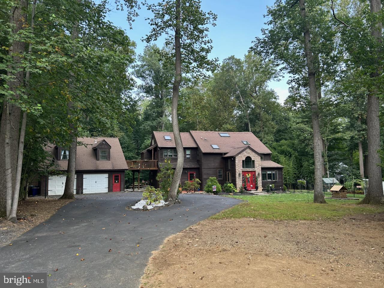 Wow is the only word to describe this incredible home! Unlike any cookie-cutter house, this stunning property boasts 5 bedrooms and 4 1⁄2 baths on nearly 1 1⁄2 acres of land. Although it feels like a country retreat, it's located in Downingtown, just minutes from shops, restaurants, and the highly acclaimed Downingtown STEM Academy.
As you approach the home, you'll notice ample parking for at least 6 cars. To the right, there's a beautiful garden and greenhouse for gardening enthusiasts. The owners have meticulously planted various trees and shrubs, including red, pink, and white crepe myrtle trees that promise a breathtaking view once matured. The rear garden features low-maintenance rose bushes and hydrangeas that bloom from spring to fall.
Inside, the house features a modern office with large windows to enjoy the greenery outside. The open-concept dining room, family room, and kitchen are perfect for gatherings, with a large island that seats six. The heart of the home is a wood-burning stove, complemented by ductless mini-splits for heating and cooling. The living room offers additional space for entertaining, while the partially finished basement includes a kitchenette and storage, perfect for game nights or a man cave.
The second floor houses four bedrooms and 2 baths, including a spacious master bedroom with vaulted ceilings and natural light. The master bathroom is cozy, with potential to expand into an adjacent bedroom. A small deck connects to a spacious modern living space above the garage, complete with a full bathroom, kitchenette, and separate entrance, ideal for an in-law suite or an AirBnB.
The backyard features a large deck, patio, and shed added last year, perfect for enjoying nature. A fire pit adds to the charm. The owners have made numerous upgrades, including a new kitchen and staining the house last year. With so many features to list, you must see this house in person to appreciate its true beauty. Don't miss out—this house will not last!