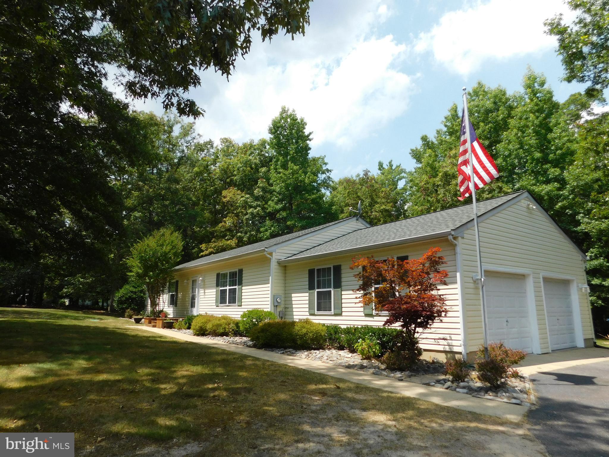 Let us peak your interest with this beautiful home that offers a winning combination of privacy and comfort! Perfectly sited on a large level lot in the quiet and peaceful community of Woodville Estates, this spectacular one-level home is sure to please. As the proud owner of this home, each time you pull into the entrance of the community and drive down the quiet tree-lined street, a sense of relaxation will begin to set in. Upon entering the paved driveway, you head for and park in the 2-car, side-load garage where you can enter the house onto laminate flooring which covers the bright and open, eat-in country kitchen and dining area. The kitchen features plenty of cabinet and counterspace, gas cooking, an island breakfast bar, and a doorway to a side room where you will find a pantry, the laundry area, and an exit door to the rear yard. From the dining area, a sliding glass door provides access to a private deck where you are sure to enjoy many moments of quiet time watching and listening to nature or entertaining your guests. Speaking of your guests, unless they come straight to the back yard to join the party, they will most likely enter your home by way of the sidewalk from the driveway that leads to the front door. So you can take their coat and they can make themselves at home as you welcome them into the living room, a coat closet is conveniently located by the front door. The living room is spacious and features a gas log fireplace and a large window for lots of light and a view of the treed front yard. Down the hall is where you will find the bedrooms to include the master bedroom with a private full bath, as well as two additional bedrooms and a full hall bath. If you are looking for a home that is in move-in condition and offers a private, yet convenient location, be sure to schedule your showing TODAY or it may be too late!