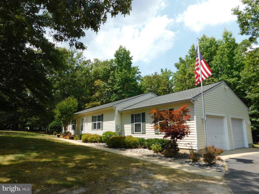 Let us peak your interest with this beautiful home that offers a winning combination of privacy and comfort!  Perfectly sited on a large level lot in the quiet and peaceful community of Woodville Estates, this spectacular one-level home is sure to please.  As the proud owner of this home, each time you pull into the entrance of the community and drive down the quiet tree-lined street,  a sense of relaxation will begin to set in.  Upon entering the paved driveway, you head for and park in the 2-car, side-load garage where you can enter the house onto laminate flooring which covers the bright and open, eat-in country kitchen and dining area.  The kitchen features plenty of cabinet and counterspace, gas cooking, an island breakfast bar, and a doorway to a side room where you will find a pantry, the laundry area, and an exit door to the rear yard.  From the dining area, a sliding glass door provides access to a private deck where you are sure to enjoy many moments of quiet time watching and listening to nature or entertaining your guests.  Speaking of your guests, unless they come straight to the back yard to join the party, they will most likely enter your home by way of the sidewalk from the driveway that leads to the front door.  So you can take their coat and they can make themselves at home as you welcome them into the living room, a coat closet is conveniently located by the front door.  The living room is spacious and features a gas log fireplace and a large window for lots of light and a view of the treed front yard.  Down the hall is where you will find the bedrooms to include the master bedroom with a private full bath, as well as two additional bedrooms and a full hall bath.  If you are looking for a home that is in move-in condition and offers a private, yet convenient location, be sure to schedule your showing TODAY or it may be too late!