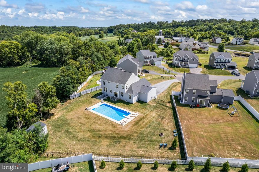 Welcome to this STUNNING 4-bedroom, 3.5-bath home in the highly desirable Springdale Farm community. Situated on one of the largest lots, this residence offers breathtaking views of the historic farm and surrounding mountains, framed by a beautiful tree line.

Step inside from the charming front porch into a grand two-story foyer. The main level is an entertainer's dream, featuring a spacious sitting room, a formal dining room, and an open-concept family room that flows seamlessly from the eat-in kitchen. The kitchen is complete with recessed lighting, stainless steel appliances, tile backsplash, a center island, and a convenient pantry. Direct access from the kitchen leads you to a spectacular backyard oasis.

Upstairs, the primary suite provides a private retreat with vaulted ceilings and an ensuite bath featuring a dual vanity, a luxurious soaking tub, and a custom tiled walk-in shower with frameless glass. Three additional secondary bedrooms share a full hall bath with dual vanity.

The lower level is a blank canvas, ready for your personal touch, with a full bathroom already in place. Electric and framing are done - ready for your creative finishes. A walk-up from this level provides easy access to the incredible backyard. Here, you'll find a 20x40 in-ground pool, a fully fenced yard, and a large shed—all set against a backdrop of scenic tree and mountain views.

Beyond the main living areas, this home also boasts a 3-car garage, perfect for car enthusiasts or extra storage. Recent updates include fresh paint in 2025, a new 5-ton upgraded heat pump and large ducting in 2025, new appliances 2025, new water softener 2025, and new wood flooring on the stairs and upper level in 2024. This home truly has it all!