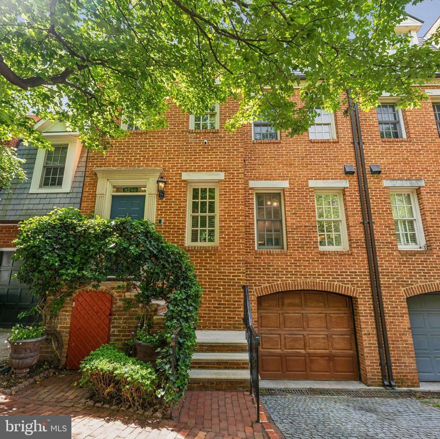 Located in the heart of Georgetown’s East Village, this elegant townhome offers over 3,200 square feet of refined living across four spacious levels, all accessible by a private elevator and complemented by garage parking. The main living level features a generous open-concept living and dining area with a wood-burning fireplace, custom built-in bookshelves, and a wall of windows highlighted by two Juliet balconies. The gourmet kitchen includes a full suite of high-end appliances and features an inviting eat-in area; a convenient powder room completes this level. On the first upper level are two large bedrooms, each with walk-in closets and en suite bathrooms. One bedroom overlooks the peaceful greenery of Book Hill Park, while the other is filled with natural light from its south and east facing windows. The entire second upper level is dedicated to the luxurious primary suite, offering a private sitting area with a wood-burning fireplace, an en suite bathroom, and a spacious balcony with treetop views. The lower level provides a versatile family or media room with another wood-burning fireplace, built-in bookcases, and a wet bar—ideal for entertaining. This level also opens to a serene, custom-designed courtyard featuring a floating deck and a charming brick terrace. A full bathroom, laundry area, and ample storage space complete the lower level. Perfectly situated for both comfort and convenience, this home provides effortless access to Georgetown’s vibrant dining, shopping, and entertainment scene.