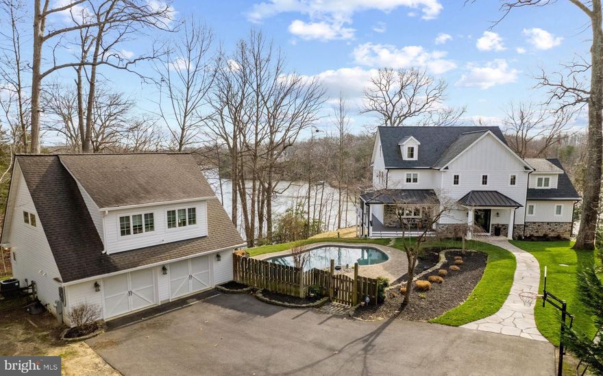 Nestled above the serene shores of Beards Creek, this exceptional, recently constructed luxury home stands as a masterpiece of contemporary waterfront living. It redefines opulence, offering an exquisite lifestyle that begins with a saltwater pool overlooking the water – the epitome of luxury. Meticulously designed, this custom home showcases rare amenities, including a 2-car detached garage with living space above, featuring a kitchenette, full bath, water view balcony and half bath just steps from the pool. Revel in the seamless blend of refined elegance and modern convenience, ensuring a hassle-free living experience with public water, public sewer and natural gas. The coveted waterfront trifecta! Upon entering the home, the open floor plan creates an inviting space for gatherings, whether intimate or grand. Unwind in the living room with the beautiful tiled gas fireplace, or savor captivating views while enjoying meals in the dining area or relax in the screened porch. The gourmet kitchen, adorned with state-of-the-art appliances and sleek quartzite countertops, effortlessly combines style and functionality. The main level provides a secluded bedroom retreat with phenomenal views, full bathroom and walk-in closet; perfect for one level living, guests, or in-laws. Your furry friends will appreciate the conveniently located mudroom with dog bath leading to the wrap around porch and pool deck. Head upstairs to discover three bedrooms and two bathrooms, including a primary bedroom suite with panoramic views, electric fireplace, spa-like bathroom and enviable custom closet. The additional 2 bedrooms are connected by a well-appointed shared bath. On the third level, a bonus room awaits, offering a haven for leisure and overlooking the creek and the pool.  The lower level with sweeping views of Beards Creek is decked out with a  custom bar with seating for 10, gym with rubber flooring plus a gas fireplace wall with an 85" television. Step outside to lounge around the saltwater pool or venture down to the water's edge with over 200 feet of waterfrontage, complete with a private pier with 10,000lb boat lift. This home represents waterfront luxury living at its finest. Welcome to a sanctuary where every detail reflects unparalleled craftsmanship, providing a lifestyle of tranquility and sophistication. Welcome Home!