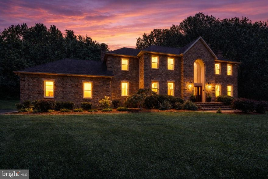 Welcome to LYONS CREEK HUNDRED — 2 DRIVEWAYS a real bonus for the Boat, RV or Extra Parking! Luxury, Space, 3.31-Acre Lot backing to mature trees — Privacy Awaits at the end of a cul-de-sac! Expansive living with this 5-bedroom, 5.5-bath all Brick Colonial offering Multi-Generational Living potential with a fully finished basement featuring its own bonus driveway and entrance. Basement Living is equipped with a kitchenette with room to expand, full bathroom, Bonus room, living room, dining area and its own pellet stove fireplace. UPDATES GALORE in this HOME! And, a BONUS WOW: New generator switch panel installed (2025) and new Generator (2025) included! Grand 2-story foyer with a MAIN LEVEL BEDROOM with its own walk-in closet and full bathroom that can also be accessed by another door off the main living room. Convenience for large families with most of these bedrooms having their own Private bathrooms. The spacious primary suite upstairs features a walk-in closet. Updated custom Quartz vanity, sinks and fixtures in the Primary Bathroom. Two separate areas to the Primary bathroom, enjoy the spa-like "take me away" area with soaking bath and the separated primary shower, vanity and toilet in its own room with a door. Continuing through the upstairs, two bedrooms with a Jack & Jill bathroom, and the third bedroom features a bathroom of its own with hallway access also. Don't miss the amazing space above the garage, a Bonus flex room perfect for play, office, crafting or workout space. Hardwood floors and crown molding that flows into an elegant formal living room with brand new pellet fireplace (2025) and open concept to dining room. Update, bonus office space/bedroom that leads right to the deck. Updated main level half bath, GOURMET kitchen with granite counters, center island cooktop (2022), stainless steel appliances, walk-in pantry, breakfast area. All-weather Sunroom off kitchen for morning coffee or entertaining in the open flowing concept from the kitchen, sunroom to the beautiful deck overlooking a peaceful backyard. Choose quiet time in either the formal or main living room both featuring a new pellet fireplace. TWO Staircases to the 2nd level, the Grand Foyer staircase and the staircase by the 3- car garage entrance to the home. Recent Upgrades & Improvements: 3 pellet stoves installed in fireplaces, August 2025. LeafFilter gutter protection (2025) - Upgraded water softener & filtration system (2025) - Full attic re-insulation for energy efficiency (2024) - New Dishwasher (2025) - Electrical updates: Ceiling fans/lights added to multiple rooms (2023) - Sunroom conversion: Bonus office with direct deck access (2024) - SmartHome sprinkler system: New controller & solenoids (2025) - New garage door spring & SmartHome opener (2024) - Invisible fence for pets (2023) - HVAC serviced & upgraded (2025) - Fresh paint in multiple rooms (2025) - Remodeled half bath (2025), driveway resealing (2025), New basement Insulated Glass door with SmartLock (2025) Previous listing updates noted, 14 new windows (2022) - 2 new HVAC units + air handler (2022) - Water heater (2016) Located minutes from North Beach BEACH & BOARDWALK, Chesapeake Beach, Herrington Harbour North & South, North Beach Boardwalk, and a variety of restaurants, shopping, parks and recreation. Close proximity to  Joint Base Andrews (19.3 miles), Fort Meade (20.8 miles), US Naval Academy (26 miles), Pax River (44.8 miles), Fort Belvoir (48.2 miles) and Pentagon about (35.3 miles)