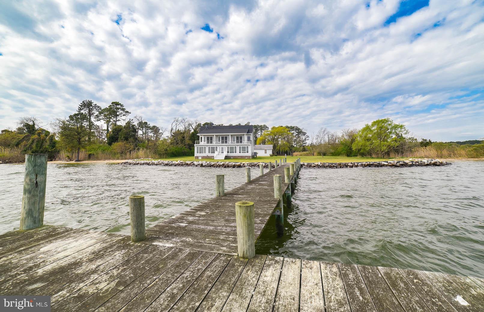 Check out the virtual tour here! https://youtu.be/72evewDLOKY Wait until you see these spectacular unobstructed panoramic water views in a serene private setting away from it all! Located at the end of St. Georges Island, this home is completely surrounded by water, natural beaches, and wooded areas. The beautiful sunrises over the St. Mary's River are enough to take your breath away! Enjoy your own private sandy beach and large flat yard with mature trees. Your 50 foot pier has plenty of space for a boat slip and is ideal for boating, kayaking, crabbing, fishing, relaxing, and more! This home is the absolute perfect spot for all of your waterfront entertaining! Constructed in 2014, this custom built Cape Cod home is sitting on 2 acres and has a relaxed coastal feel with almost 2600 sf of living space. Inside you will find 3 bedrooms, 2.5 bathrooms, custom accordion shades, recessed lighting, ceiling fans, hardwood floors and ceramic tile throughout, and so much more. The exquisite kitchen has imported granite, stainless appliances, a Jennair convection range, custom island and cabinets with glass doors and lighting, and soft close drawers. The kitchen opens up to the dining/living area with amazing views of the water through the walls of high quality Andersen windows. Enjoy the gas fireplace and the ambiance it brings in the cooler months. The Master bedroom with lavish bath is upstairs along with a separate living area with wet bar for your indoor entertaining. The upstairs terrace/balcony is amazing! It s the entire length of the house facing the water, providing you with sweeping water views, and your private waterfront with expansive professionally installed rip rap. The detached oversized 2 car garage and large driveway provides plenty of space for storage and parking. In 2015, the owner had lines run to obtain public sewer to the property a rarity in this area. Check out this waterfront beauty today! It could be yours just in time for Spring/Summer!