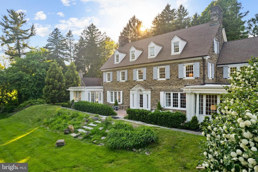 This exceptional Wissahickon Schist estate was designed by Robert McGoodwin in 1919, and masterfully refurbished for today’s lifestyle. Set on nearly an acre just steps from the Wissahickon trails, the property offers 7,600+ sq ft of refined living, elaborate stone walls, blue stone and brick walkways, a potting shed, guesthouse, two-car detached garage, and an expansive parking court.

Inside, natural light fills every room. The main level includes a grand front-to-back entry hall, formal living room, dining room,  paneled library, all with fireplaces. A gourmet kitchen with butler’s pantry, and prep room, a sun-filled family room,  and a stunning pub room that opens to a south-facing brick terrace complete the main floor. The second-floor primary suite includes a sitting room, marble bath, and generous closets. Additional junior suite with private bath, two other bedrooms, updated hall bath, and a laundry room are all located on the second floor. The third floor has  three additional bedrooms, a family room / flex space, fully updated bathroom, and ample storage spaces.

Extensively updated, including kitchen, baths, windows, floors, landscaping, and a new four-zone heat pump system (plus a fifth in the guest house), with recirculated water radiator heat for year-round comfort.

A rare opportunity to own a landmark residence where historic architecture meets modern living—steps from the Wissahickon trails and just minutes to Center City, offering the best of both nature and city convenience.