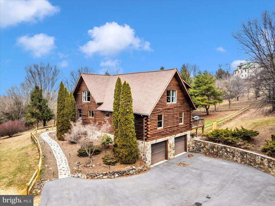 A truly rare offering, this classic and authentic log home showcases beautifully stained timbers, traditional corner notching, and a stone foundation, all set on a serene 2.77-acre homesite in a peaceful rural setting. Inside, the main level features an open floor plan with fully exposed log walls highlighting natural knots and character throughout. The great room offers solid oak flooring, a striking stone wood-burning fireplace, and dramatic vaulted ceilings that reveal exposed log rafters and substantial oak beams, creating a warm, lodge-like atmosphere. The great room flows seamlessly into the kitchen, which includes a large island, Craftsman-style cabinetry with distinctive hardware, and space for a kitchen table, along with a dining alcove open to the main living area. Two bedrooms, a full bath, and a dedicated laundry room complete the main level. Upstairs, an 18' x 15' loft with pine flooring and vaulted ceiling overlooks the great room and is filled with natural light. The owner’s suite is generously sized at 24' x 17' and features a large walk-in closet and a spacious private bath. The lower level offers a finished recreation room and a versatile bonus room.  Outdoor living is equally inviting, with a raised 19' x 8' covered front porch, a large deck, an enclosed cabana and hardscaped terrace. A large, fenced area and storage shed adds to the property’s appeal. This well-maintained Lincoln Log home offers exceptional warmth, charm, and coziness.  You will truly love calling it home.