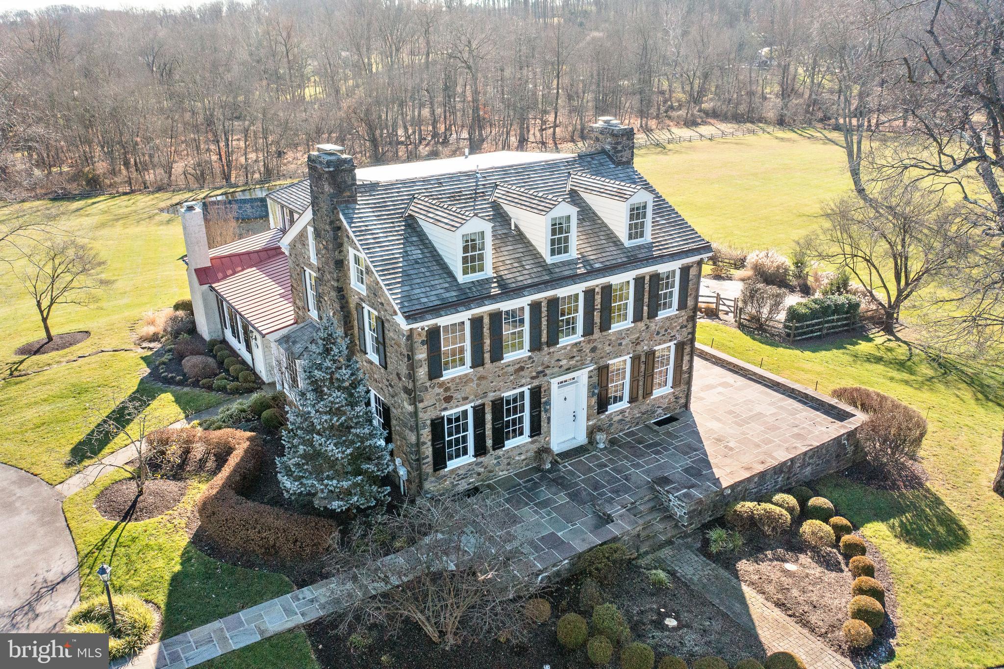 Welcome to 158 Grubb Rd- with multiple dwellings, original character, and modern amenities, this beautifully preserved historic property in the heart of Radnor Hunt is ready for the discerning buyer. Spanning just under 16+ pastoral acres, this expansive property hosts a traditional main house, detached four car garage, beautiful bank barn with stalls and large entertaining area above, a spring house connected to the fresh water pond, and a private in-ground pool. Nestled along a private lane in top rated Great Valley School District, this truly captivating home is one of a kind. At first glance, you are greeted by a large circular driveway leading to a parking pad which provides direct access to both the main house and the detached four car garage. This unique garage hosts additional storage space along with a convenient full bathroom. Enter through the front door and you are greeted by beautifully refinished hardwood flooring, detailed moldings and wainscoting, and 10ft+ ceilings. The stately formal living room offers a wood-burning fireplace, detailed moldings, solid wood built-ins, and a private entrance to the side patio which overlooks the breathtaking grounds and is perfect for watching the sunsets. A handsome office sits just across the hall, complete with a wood-burning fireplace, picture molding wainscoting, and two walls of built-ins. The nearby dining room offers plenty of natural light and is a welcoming space to entertain. Follow through to the gourmet kitchen, filled with solid wood cabinetry, a 5 burner cooktop with hood, a double wall oven, and a secondary prep sink that leads into the sun drenched breakfast room. Adorned with paneled wainscoting, exposed beams, and solid wood built-in shelving with a charming window seat, this dining area provides direct access to the deck- ideal for alfresco entertaining. Next is the spectacular great room, anchored by a stone wood-burning fireplace which is beautifully accented with exposed wooden beams and recessed lighting, truly the heart of the home! The side entrance offers a charming mudroom with an exposed stone wall, original wood beams, tile flooring, and a curved archway leading into the great room. Two half bathrooms service this level, located at opposite ends of the house. Four bedrooms fill the second level of this home, including the primary suite which hosts a walk-in closet and private ensuite bathroom with a soaking tub and stall shower. Bedroom #2 has its own own private ensuite bathroom, while bedroom #3 and #4 share the use of a full hall bathroom. Conveniently located on this level is the laundry room and a large linen closet. The third floor hosts two ensuite bedrooms with an abundance of closet space in both the bedrooms and the hallway. The finished basement features additional living space and a work out area. The fully functional bank barn hosts stalls in the lower level, while the second level is the ideal spot for entertaining. A charming springhouse services the pond while the secluded pool is perfect for those warm summer months. Close to many top private academies, downtown Wayne and Malvern Borough, and easy access to all major roadways for an easy commute to Philadelphia, Wilmington, and NYC- this unique property truly is one of a kind and a rare find in the desirable Radnor Hunt area! Call today for more information!