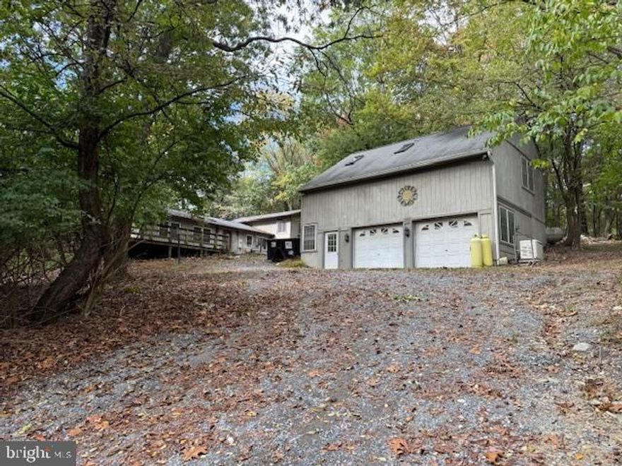 Secluded 3.4-Acre Property with Multi-Use Potential – Frederick County, MD

Private 3.4-acre property off Indian Spring Road in Frederick County. Wooded setting with a creek and deeded easement access via a gravel lane leading to a secluded homesite. Located outside city limits with no city taxes.

The home is livable and functional but needs work and updates. The main level features an open-concept living and kitchen area with a woodstove and sliding glass doors leading to a wraparound deck overlooking the woods. One bedroom with a walk-in closet, full hall bath, and laundry room off the kitchen. (Originally a two-bedroom layout that could be easily converted back.)

A connecting room currently used as a library leads to a separate upper-level living unit with a full kitchen, living area, bedroom, full bath, and private deck with its own exterior entrance. Perfect setup for multi-generational living, an in-law suite, rental income, or short-term rental use.

The detached two-car garage includes a finished, insulated, and conditioned upper level with a private entrance—ideal for a home office, studio, or small business space.

Property is being sold as is. Solid structure with significant potential for renovation, expansion, or investment. Excellent opportunity for buyers seeking privacy, flexibility, and acreage close to Frederick.