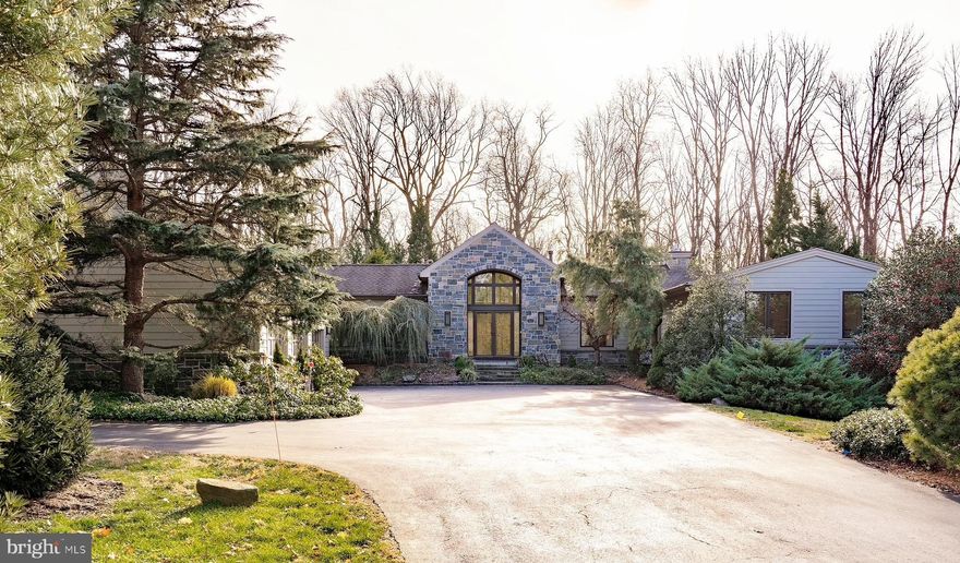 A long private tree lined drive leads you to a perfectly situated 2+ acre estate, surrounded by over 100 mature specimen plantings, in a most sought after location. Updated throughout to the highest standards with timeless appointments, breathtaking architectural features and expansive walls of windows to take in the breathtaking surroundings. The mature plantings allow for privacy and make this home feel like a sanctuary. The new field stone and hardiplank facade was thoughtfully completed to complement the original design. Enter this light-filled luxurious home through the arched double doors and you are immediately drawn into the living room with a dramatic two story wall of windows overlooking the picturesque grounds, which rival any arboretum. From the main entry foyer find ample closet space and a nicely appointed powder room. The marble floored hallway leads you to the show stopping gourmet kitchen with vaulted ceilings, center island with prep sink and 5 burner gas cooktop, designer light fixtures, quartz and leathered granite countertops, ample white cabinetry and top of the line appliances including a Subzero refrigerator. A frosted glass door opens to a walk in-pantry offering generous storage, double wine refrigerators, an additional dishwasher and a prep sink. The Kitchen is open to the sunlit breakfast room surrounded by floor to ceiling windows allowing you to take in the peaceful vista while enjoying a meal. The great room has vaulted ceilings, large picture windows, gas fireplace, built-in bookshelves and opens to the blue stone patio with a seating area perfect for indoor/outdoor living. The heated sunroom has 270 degree views of the scenic gardens, a perfect place to read a book in any season. The sunroom is open to the living room, dining room and great room, adding to the home's open floor plan with a gracious flow for grand and effortless entertaining. The spacious dining room is sunlit with french doors to the sunroom allowing in the natural light. A study with built ins is tucked away from the main living spaces making working from home not only comfortable but private. A double door entry welcomes you to the Owner's suite, with panoramic treetop views of evergreens from the architecturally interesting windows. The Owner's suite is a retreat in every sense of the word with a cozy gas fireplace to sit beside, and sliding glass doors that open to the new ironwood deck with state of the art spa overlooking acres of wooded grounds. Two walk in custom outfitted closets, a dressing area and a new  spa like bath with designer soaking tub, glass surround shower, heated towel racks, and custom walnut vanities complete the suite. Down another hallway find two additional spacious bedrooms that share a large hall bath with double sink vanity and soaking tub, both with access to a deck that runs along the back of the house. This wing also has a newly appointed laundry room with granite counters. Access to the mudroom and pantry is conveniently located off the 3 car garage that has additional second story storage. The daylit lower level has a family room with expansive glass windows allowing for an abundance of natural light and a gas fireplace, a great casual space. There are two additional bedrooms and two full baths with designer tile and vanity storage on this level, as well as a home gym. In the large storage area there is a second washer and dryer. Escape to the multiple outdoor living spaces and take in the views of your private oasis and in the summer months enjoy the 60 ft heated lap pool which has been recently completely redone. No detail has been overlooked, surround sound in & out, dual zoned hvac, smart lighting control, a whole house generator to assure your comfort and safety. All of this just minutes to Philadelphia, in the heart of the Main Line , near all major roadways & an easy commute to NYC. In Award Winning Lower Merion School District. Call for your appointment to view this stunning estate.