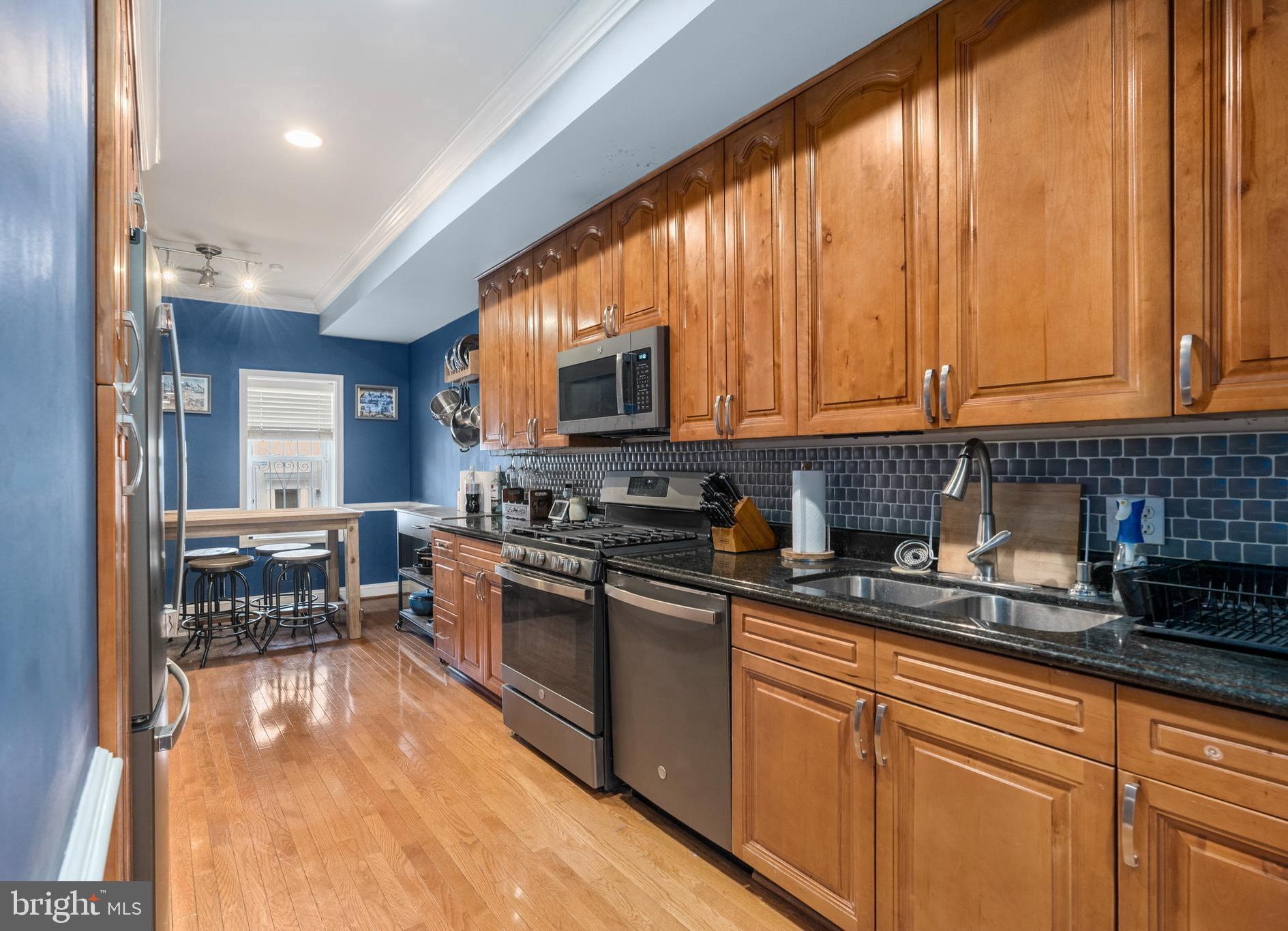 This well maintained beautiful brick front home in Pig Town's Historic District has rooftop views of the entire Baltimore skyline! Enjoy stylish and sleek modern amenities with an original brick accent wall when you enter, and gleaming hardwood floors, recessed lighting throughout the open living and dining room, into the kitchen featuring granite countertops and slate appliances with less than a year old 5 burner gas stove and oven with air fryer. There is also a half bath, and laundry in an alcove behind the kitchen. Upstairs is a spacious newly carpeted Primary bedroom with ensuite bathroom, and french doors that lead out to a deck with a spiral staircase to the rooftop deck. There is a second bedroom with new carpet and full bathroom in the hallway. The lower level is fully finished and is a great place for a family room, recreation room or office. Recent updates include the the Trex deck off the Primary's bedroom with a spiral staircase to the updated Trex rooftop deck with views in all directions of the ballparks, Top Golf, and B&O Railroad. The furnace was recently replaced. Walk to the ball parks, shops and restaurants. Conveniently located close to I-95 and commuter trains. Don't wait, schedule your tour today!