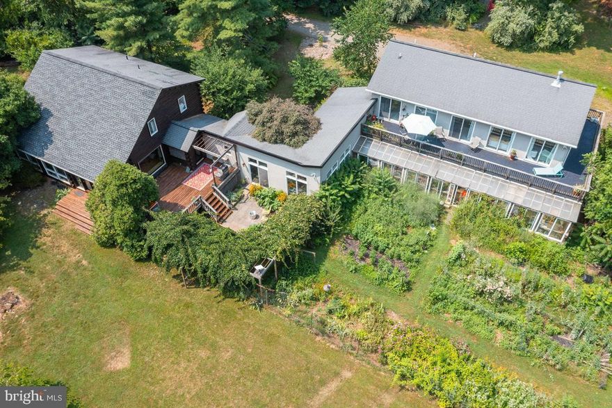 High speed Starlink internet  supports work (remote) from home.  Ideal set up!!  10 acres tucked into the rolling Piedmont of Virginia with ultimate privacy.  5605 Pignut Mountain Dr is a light-filled artist's and a nature lover's dream. A  log home with 2005 stucco addition has a mid-century vibe, 4 bedrooms, and 4 full baths with 4 car garage, massive separate in-law suite,  large greenhouse, surrounded by mature gardens and woodland trails.
Beauty and nature abound as you enter this wooded wonderland into the sprawling two-level home with ample room for your family and multi-generational living! 
Upon entry from the double doors, the entry foyer leads into the kitchen and dining area with rustic charm, high-end modern appliances, and a gas 6-burner oven! The dining area has a massive picture window looking upon the beauty of the deck, patio, pond, and private oasis. The dining and living room flooring is gorgeous Carlisle wide plank white pine flooring.   The solid wood walls and open beamed ceilings exude the quality and charm of this unique log home. A small bar and two additional office or sun rooms are also adjacent to the living and dining rooms. Upstairs in this section of the home are three bedrooms, including the primary bedroom with vaulted ceilings, wood beams, and floors, as well as a full bathroom on this level.
 The second entrance is level entry to the family room with high ceilings, a kitchenette with wet bar, and private remodeled full bath with shower and grab bars.
From the second entrance or the massive 4-car garage, you can go upstairs to the in-law apartment above the garage. This large and modern space is light filled with luxury vinyl plank flooring, double-sided fireplace, an additional full kitchen, full bathroom, large bedroom and an additional room currently being used as a bedroom. A huge wrap-around deck with great property views and gardens is off the living area. There is a 5-bedroom septic system, so an additional bedroom is possible. 
Outside, the beautiful gardens are extensive! Overhanging trellis, multiple decks and patios make this home inviting and special! The property has a swing/playset, pond and numerous trails. Come explore this enchanting property today!