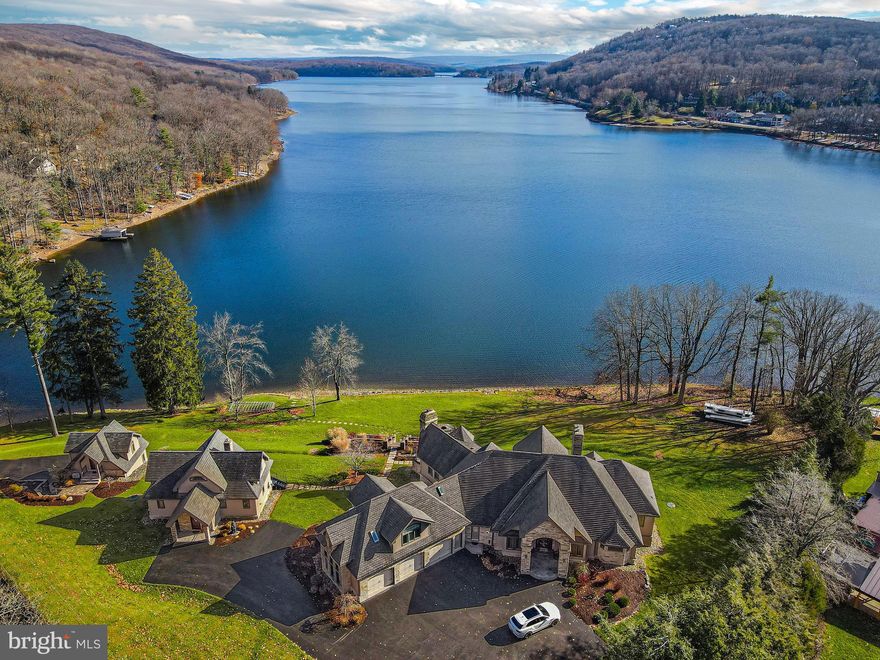 Stunning expansive views from this 464' premier lakefront estate with three masterfully designed houses and 8-permitted dock slips.  Centrally located in the heart of Deep Creek Lake area having every amenity within minutes away.  This unique property hosts a five ensuite bedroom Main house with two bonus rooms, in-law suite, two ensuite bedrooms plus two more bedrooms in the Guest house, and a carriage house, gas and wood fireplaces, large entertaining kitchen with living space and breakfast nook, geothermal heating/cooling, indoor and outdoor heated floors, two family rooms, game room, formal dining room, remote security and utility systems, gated driveway, and for more overflow two guest houses.  The unobstructed views are captured from every angle on this property.  Wake up to coffee on the multi-levels of terraces and patios as an amazing permanent residence, weekend escape, or even corporate retreat.  This estate promotes lifestyle in every season that Deep Creek Lake has to offer. (mls details, square feet, and specifications are on the main house only)