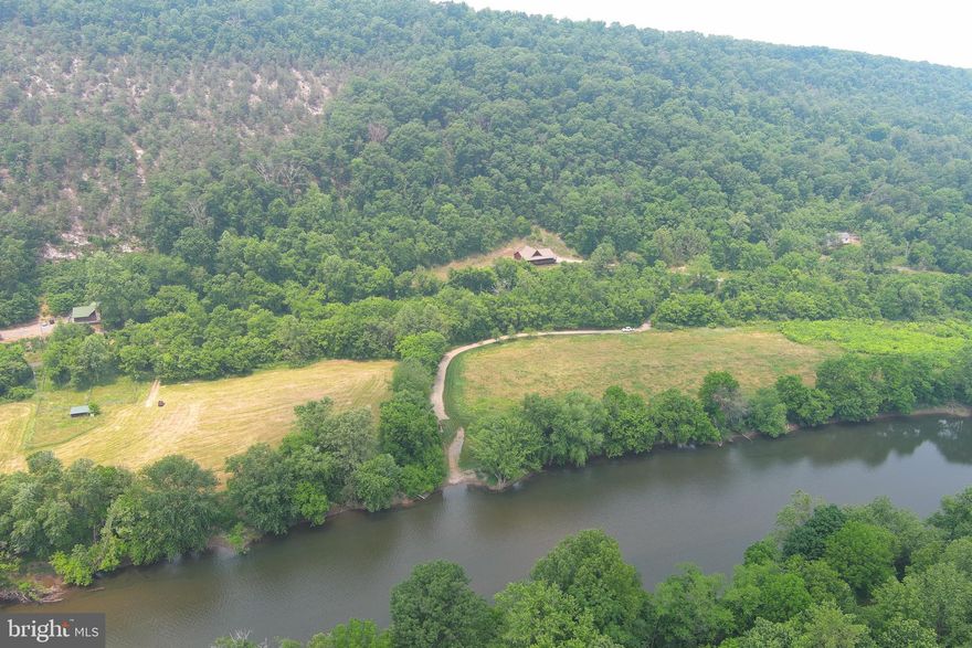 RIVERFRONT LOG MASTERPIECE.......CUSTOM LOG HOME ON NEARLY 19 ACRES WITH 596 FT OF FRONTAGE ON THE SOUTH BRANCH OF THE POTOMAC RIVER. HOME FEATURES SPACIOUS ROOMS, HARDWOOD FLOORS, CUSTOM MASTER BATH AND HUGE WRAP AROUND PORCH.......TREMENDOUS MOUNTAIN & RIVER VIEWS TO ENJOY FROM YOUR ROCKING CHAIR! 9 TIMES OUT OF 10, HOMES LIKE THIS ON THE RIVER ARE BURIED BACK MILES OF DUSTY ROADS......NOT THIS ONE.....DIRECT FRONTAGE AND ACCESS VIA A QUIET PAVED COUNTRY ROAD.....SUCH EASY ACCESS, A PRIUS OR PORSCHE WILL GET HERE WITH NO PROBLEMS.....ONLY 20 MINUTES FROM CUMBERLAND, MD.....30 MINUTES FROM ROCKY GAP RESORT, CASINO & GOLF! HOME IS ON ONE SIDE OF THE PAVED ROAD, HIGH & DRY OUT OF THE FLOOD ZONE, CROSS THE ROAD ON YOUR ATV AND DRIVE TO THE RIVERS EDGE.....THE ACCESS TO THE RIVER COULDN'T BE EASIER, BOAT LANDING IN PLACE AND CUTE LOG RIVER SHED.....FRUIT TREES AND 4 ACRE HAY FIELD COULD BE EASILY UTILIZED FOR A FAMILY SOCCER OR FOOTBALL FIELD. EASY ACCESS TO MILES OF RIVER TO FLOAT, FISH & EXPLORE......THIS PLACE HAS IT ALL AND ISN'T MISSING A THING! START LIVING THE DREAM TODAY!