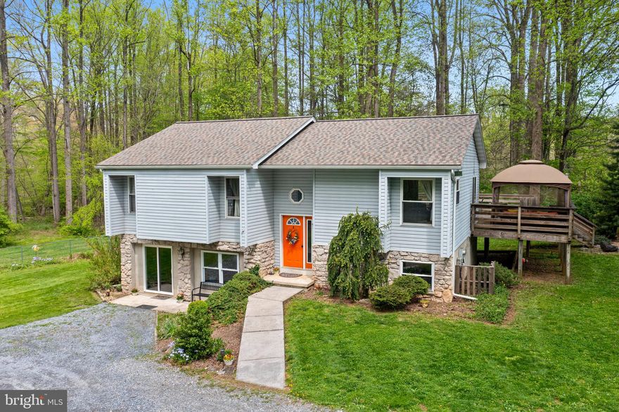 Escape to your own private retreat with this beautiful home situated on a double lot with 5.25 serene acres, complete with a picturesque flowing stream and plentiful mature hickory trees. Nestled in a peaceful setting, this property offers the perfect blend of natural beauty, privacy, and everyday comfort.
The home features 3 bedrooms and 2 full bathrooms, with a spacious layout designed for both relaxation and entertaining. Large windows bring in abundant natural light and frame calming views of the surrounding landscape. The kitchen offers ample counter space and flows seamlessly into the living and dining areas. New roof in 2026.
One of the standout features is the expansive wrap-around deck—an ideal space for morning coffee, outdoor dining, or simply enjoying the quiet beauty of the property. Step outside and explore your own private nature setting, complete with walking / bike trails winding through the 5+ acres, a tranquil stream, and an abundance of mature hickory trees that add both charm and seasonal character.
A detached garage provides valuable storage, workspace, or room for vehicles and equipment, adding convenience and versatility to the property. Additional highlights include: Expansive 5+ acre lot, Scenic stream running through the property, Mature stand of hickory trees, Private walking trails throughout the land, Wrap-around deck for outdoor living, Sheds and gardening space; all located within a peaceful and secluded setting surrounded by nature. 
Whether you're looking for a quiet homestead or a nature lover’s dream property, this is a rare opportunity to enjoy space, privacy, and natural beauty all in one place. Schedule your showing today.