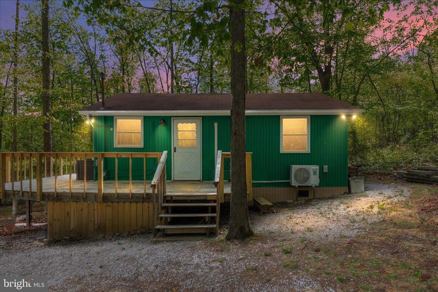 Tucked away in the peaceful community of Sleepy Hollow, this inviting 2 bedroom, 1 bath cabin on 2.07 acres offers the perfect escape into nature. Surrounded by mature trees and natural beauty, the property provides a true sense of privacy that is ideal for relaxing weekends or a quiet full-time retreat. Inside, you’ll find a cozy layout that has many recent updates. The current owners have replaced flooring, added a new mini split, replaced multiple fixtures, new hot water heater and filtration system along with many other updates. See complete list in documents! Plenty of natural light throughout the home adds to the homey and comfortable atmosphere this cabin offers. Step outside to the oversized deck and you are surrounded by trees and the sounds of nature. Feel free to relax by the newly constructed firepit area that is perfect for gatherings. As part of the community, you’ll also have access to a variety of amenities, including a beautiful spring-fed lake complete with a sandy beach and docks. The lake is perfect for fishing or simply soaking in the views. Additional features include a ball field and a picnic area, making it easy to enjoy time outdoors with family and friends. If you’re looking for a private getaway with access to outdoor recreation and community charm, this Sleepy Hollow cabin is the perfect match.