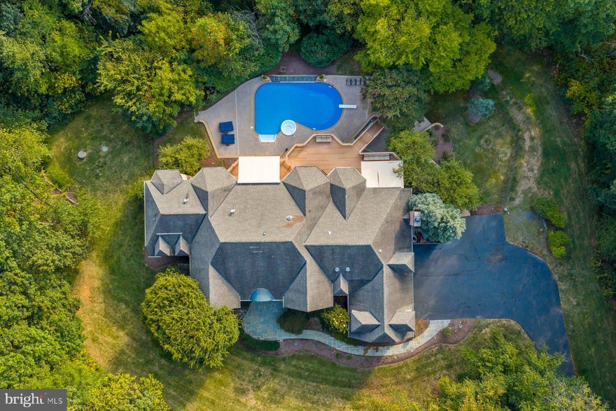 Experience refined living in this exceptional Schultz custom home, perfectly set on a three-acre estate surrounded by trees and natural beauty. Boasting almost 11,000 square feet of refined living space!!Offering complete privacy and a serene atmosphere, this residence was thoughtfully designed with comfort and versatility in mind. The thoughtfully designed layout includes a first-floor owner’s suite as well as a second suite upstairs, providing flexibility and comfort for family or guests.
The updated basement expands the home’s living space with a generous sized, newly constructed den that can be used as a bedroom or study, a modern bath, a glass-doored fitness studio, and a flexible room ideal for yoga, crafting, or creative pursuits. The gourmet kitchen features premium stainless steel appliances and custom finishes, perfect for everyday living and entertaining alike. Soaring two-story living and family rooms, along with five fireplaces, offer inviting spaces to gather and unwind. Two brand new hot water heaters and a brand new water filtration system add to the home's modern comforts. 
Outdoors, the property transforms into a true resort-style escape. The infinity-edge pool is accompanied by a built-in spa, offering both refreshing swims and soothing relaxation. Multiple patios and lounge areas provide abundant space for sunbathing, outdoor dining, and entertaining, while the expansive deck and screened-in porch allow for year-round enjoyment overlooking the pool and natural surroundings. Whether hosting summer gatherings, enjoying a quiet evening under the stars, or relaxing with family, this outdoor haven is designed for both fun and tranquility.
The brand-new Beacon Hill Golf Club has been re-imagined into an 18-hole championship course featuring multiple tee options, dramatic elevation changes, and sweeping views for golfers of every level. Members can look forward to an exclusive, luxurious clubhouse opening in summer 2026, along with state-of-the-art practice facilities and social spaces designed for both relaxation and connection. The club offers a variety of membership packages — from full golf privileges to social and practice-only access — with special pricing available exclusively for Beacon Hill residents. Whether you’re seeking competitive play, family-friendly fun, or a vibrant social scene, the new Beacon Hill Golf Club delivers a lifestyle of prestige and convenience right at your doorstep.
Blending elegance with livability, this estate is more than a home—it’s a lifestyle. Don’t miss the chance to make this exceptional property yours.