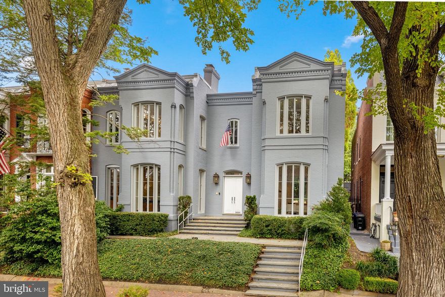 Award-winning and architecturally significant, 2813 Q Street is one of Hugh Newell Jacobsen’s earliest and defining Georgetown works. Designed in 1962, reconciles the Old Georgetown Act’s preservation standards with Jacobsen’s modernist clarity and precision. Behind its 19th-century façade lies a luminous world of soaring space, geometry, and proportion—a timeless expression of Washington modernism.

A double set of entry doors opens to a two-story atrium more than twenty feet high, capped by glass ceilings and framed by tall doors to the garden and public rooms. The scale accommodates full trees indoors, while a discreet bar and deep coat closet are built in seamlessly and are hiding in plain sight. To the right, the expansive living room with massive fireplace features a south-facing bay window and glass doors to the garden. On the west side of the atrium, a south-facing library offers large windows, a fireplace, and custom cabinetry. Across the bluestone hallway is a perfectly square dining room with tall connecting doors that creates a singular flow, ideal for entertaining. The immense marble-and-stainless kitchen is filled with light and garden views, it too has a fireplace, and multiple exits to the terrace, and all the practical elements of a true chef’s kitchen. Further down the hall lies the original 1880s staircase, with lower-level stairs and a generous powder room tucked behind them. The lower level provides a lot of dry storage and laundry.

Upstairs in the original house are two bedrooms, each with a unique marble-and-glass bath and wonderful views. The adjoining family room, lined with Jacobsen’s signature shelving has treetop vistas, and leads across a glass bridge spanning the atrium to the primary suite—an inspired composition of light and privacy. The suite includes a large, garden-facing bedroom, a fitted dressing room ample enough for a sitting area or gym, and a striking black marble bath. French doors open to a private balcony with a spiral staircase ascending to a remarkable roof deck overlooking the garden and Georgetown’s rooftops.

The garden, designed by landscape architect Lester Collins, extends across a double lot in layered terraces of bluestone and brick centered on a broad lily pool framed by clipped Deodar cedar. It remains one of Georgetown’s most extraordinary modern landscapes—a perfect counterpart to Jacobsen’s architecture and a masterclass in the union of modern form and natural grace.
