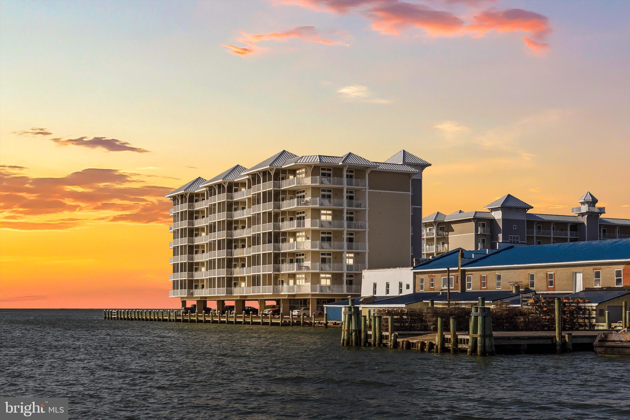 Amazing views of the Chesapeake Bay, Tangier Sound, Smith and Tangier Islands, and more! This direct Bayfront unit, located on the 5th floor, features uninterrupted views and Incredible Sunsets. From both the main living area and the primary Bedroom, featuring both an open Terrace and a Screened Balcony. The fresh salt air breeze will take away all your stress and let you completely relax. Crisfield is the quiet resort , and a waterman's paradise. Located near restaurants, bars, and close to tour boats traveling daily out to Smith and Tangier Islands, Harbour Lights features a great inground pool with a large sun deck for beautiful summer days and an expansive marina with private boat slips available for purchase in its protected cove.
This Fully Furnished "Turn-key" unit features a large primary bedroom with a spacious en-suite bath, walk-in closet (and of course amazing views), then 2 more large rooms and another full bath. The roomy Kitchen with wide Corian counter tops has lots of room to cook for everyone without being left out of the fun, as it adjoins the Dining area and Living room featuring an Electric Fireplace to stay cozy while you look out over the bay. This unit is perfect year-round due to its location in the building, which keeps it sheltered from the north winds of winter and the southern direct sun of the summer. The Unit also features lots of large closet space and a Private storage room outside of the unit for all your toys and boating supplies. This unit has been used exclusively by the owners, so the furnishings and the unit are in great shape. Summer is almost here. Isn't it time you reward yourself with your own piece of paradise!